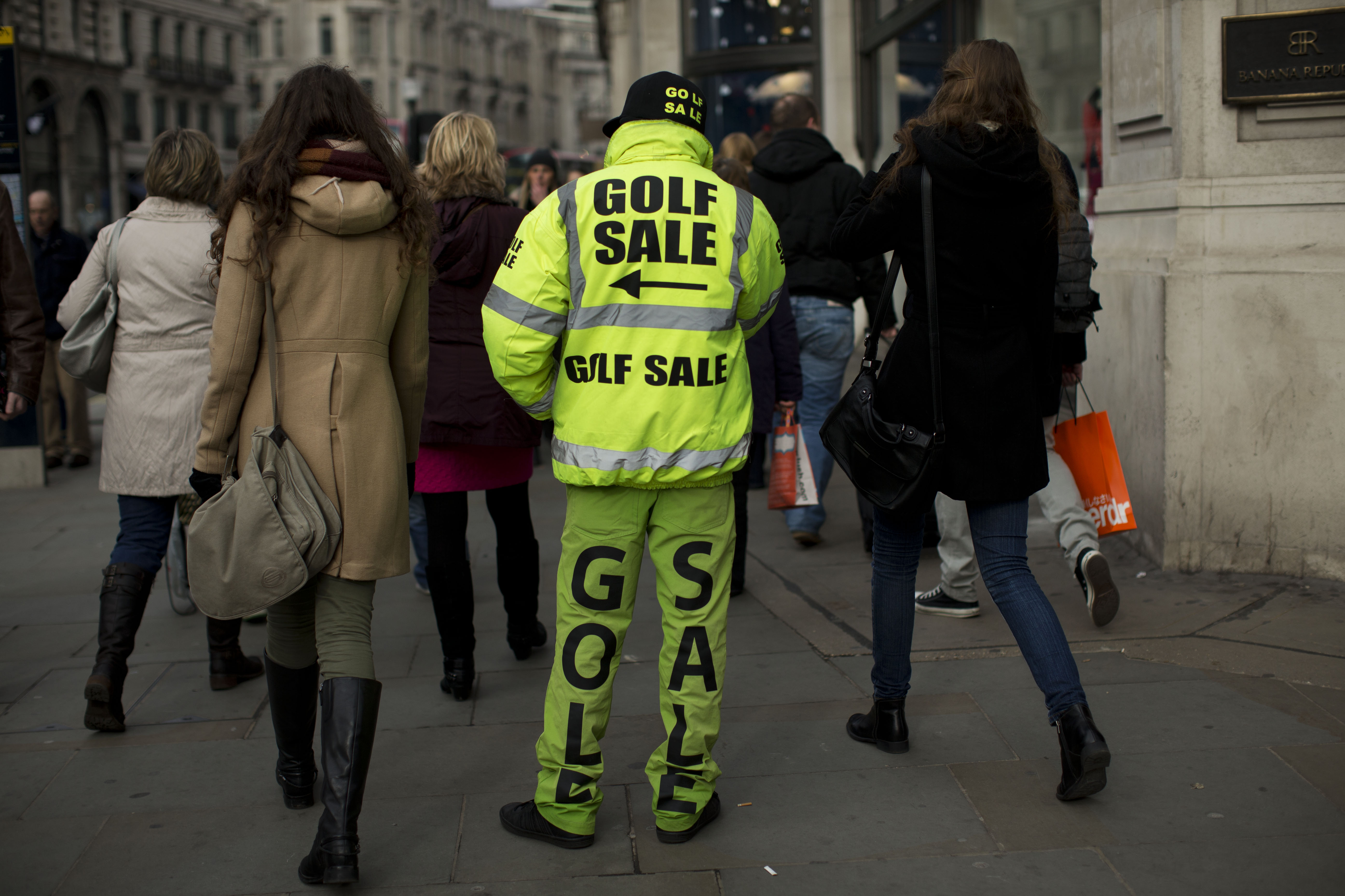 A man advertises a golf sale on Regent Street in London, Wednesday, Feb. 20, 2013. (AP Photo/Matt Dunham)