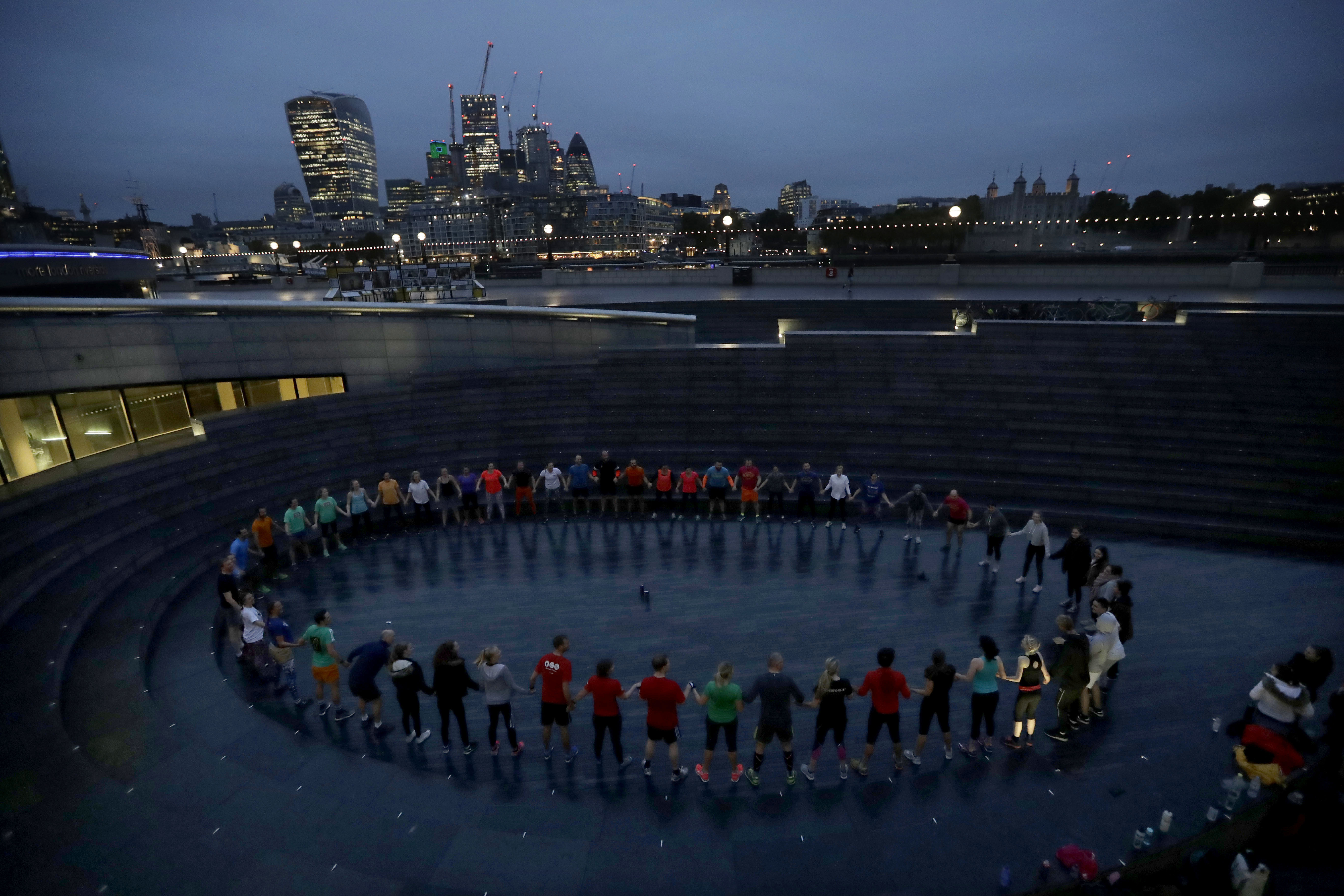 People take part in early morning exercise in 'the Scoop' an outdoor amphitheater near City Hall by the River Thames in London, Wednesday, Oct. 18, 2017. (AP Photo/Matt Dunham)