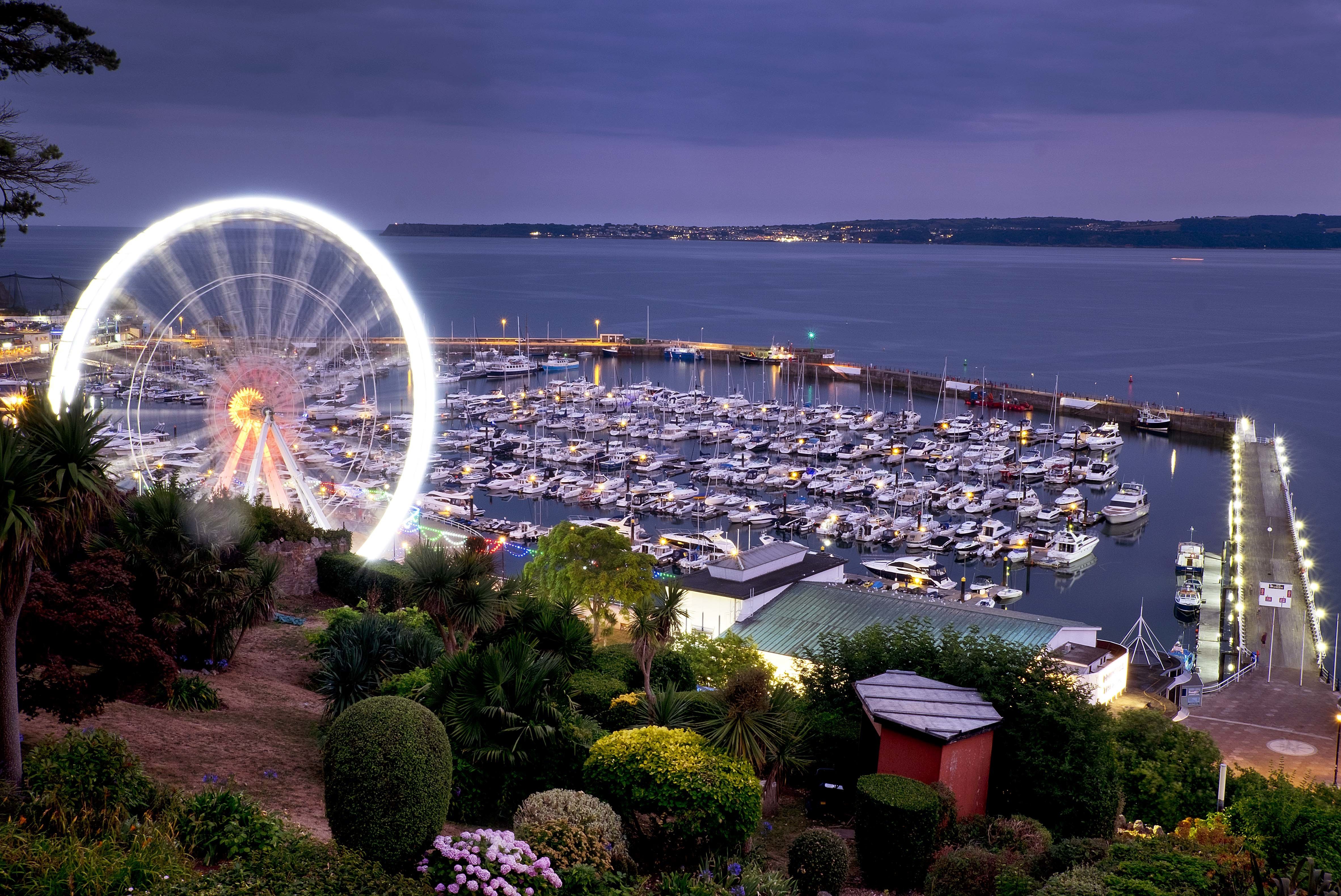 A ferris wheel turns next to the harbor in Torquay on the south coast of England, on Saturday, July 21, 2018. AP Photo/Michael Probst)