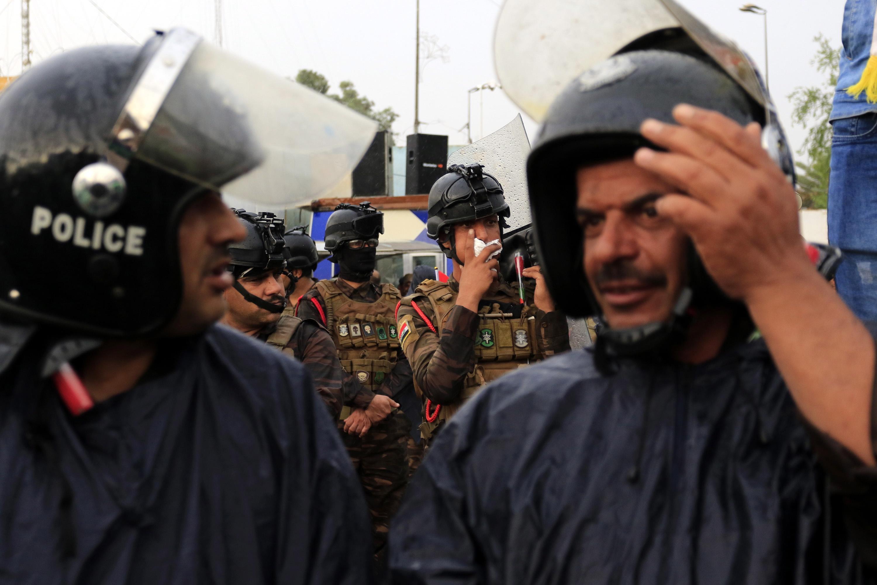 epa07949550 Iraqi riot police forces stand guard as Iraqi protesters take part in a demostration in Karbala, Iraq, 25 October 2019. Thousands of protesters in Baghdad and southern Iraqi cities staged new protests against the Iraqi government corruption and poor government services. At least 20 protesters were killed and dozens others were wounded during clashes with riot police forces in Baghdad and Nasriyah city southern Iraq.  EPA/FURQAN AL-AARAJI