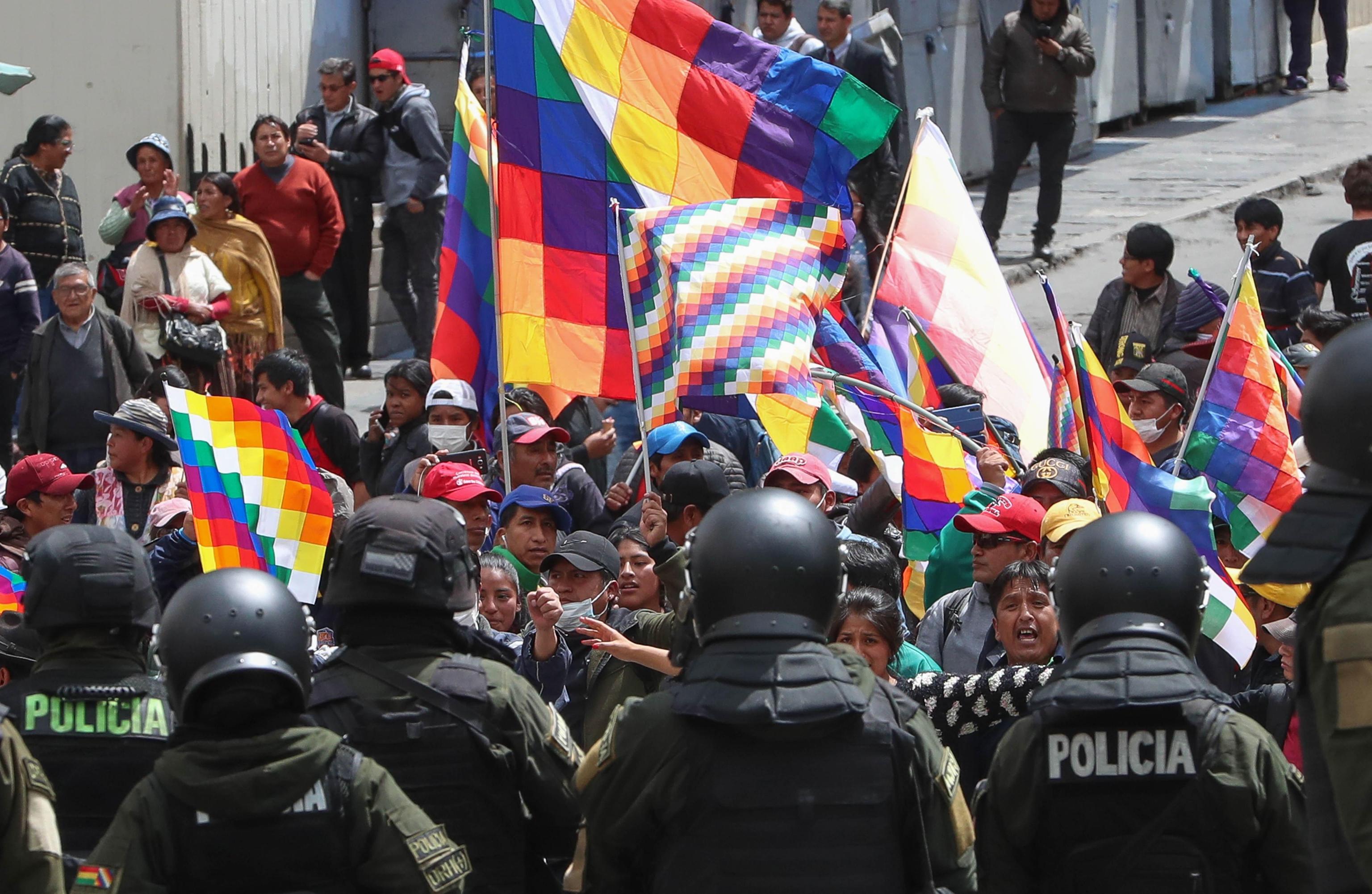 epa08000419 El Alto citizens along with supporters of former President Evo Morales march while Bolivian military and police guard the surroundings of Plaza Murillo, in La Paz, Bolivia 15 November 2019. Bolivia is plunged into a crisis after the elections of October 20, with at first opposition protests against Evo Morales over allegations of fraud to achieve his fourth consecutive term, and now after his resignation Morales supporters protesting against the interim government of Jeanine ÃÃ±ez.  EPA/MartÃ­n Alipaz