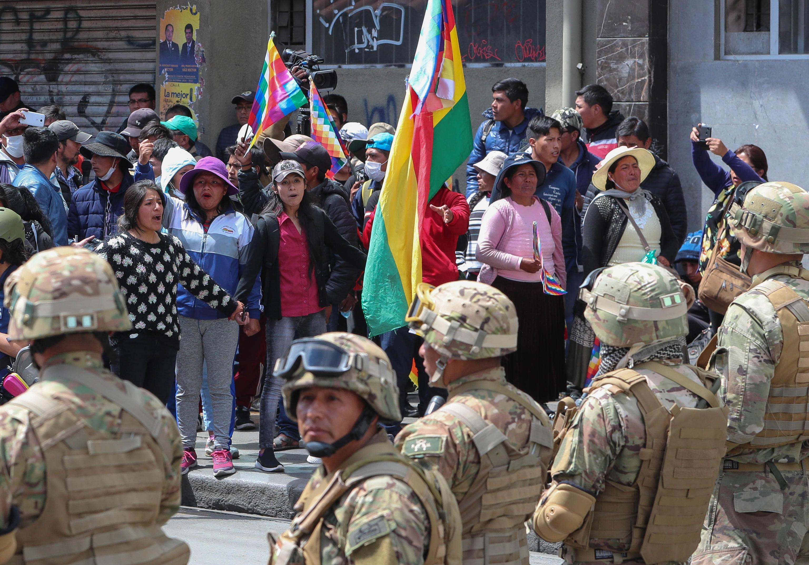 epa08000417 Bolivian military guard around the vicinity of Plaza Murillo while thousands of citizens of El Alto along with supporters of former President Evo Morales march in La Paz, Bolivia 15 November 2019. Bolivia is plunged into a crisis after the elections of October 20, with at first opposition protests against Evo Morales over allegations of fraud to achieve his fourth consecutive term, and now after his resignation Morales supporters protesting against the interim government of Jeanine ÃÃ±ez.  EPA/MartÃ­n Alipaz