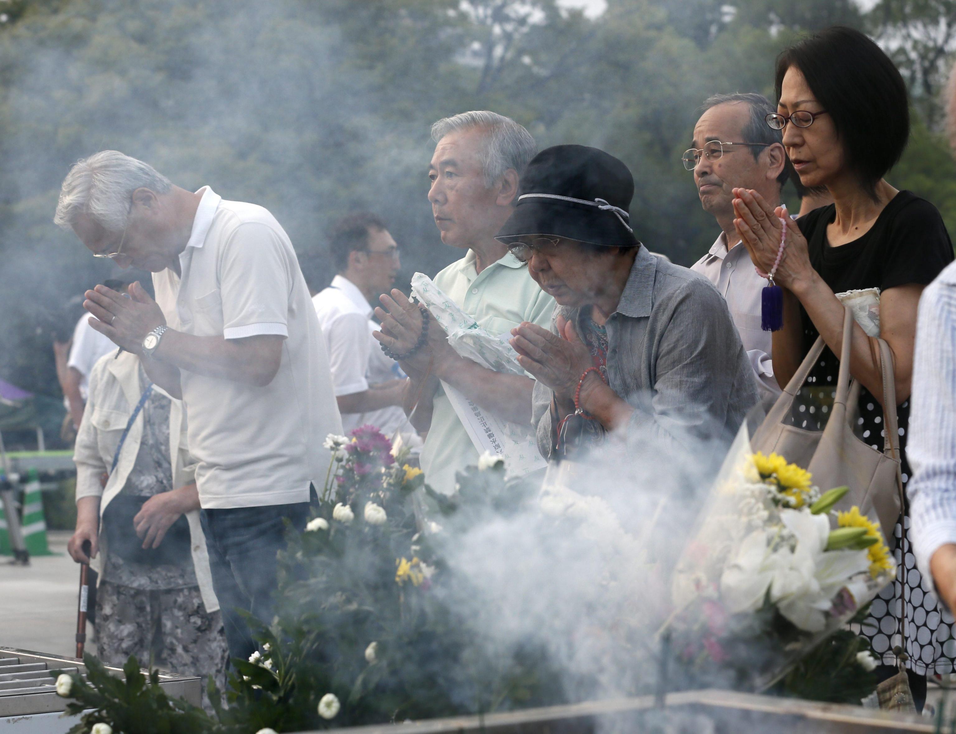 epa03814169 Residents offer a prayer for atomic bomb victims at the Hiroshima Peace Memorial Park in Hiroshima, western Japan, 06 August 2013 prior to the Peace Memorial Ceremony marking the 68th anniversary of the world's first atomic bombing of a city in 1945.  EPA/KIMIMASA MAYAMA