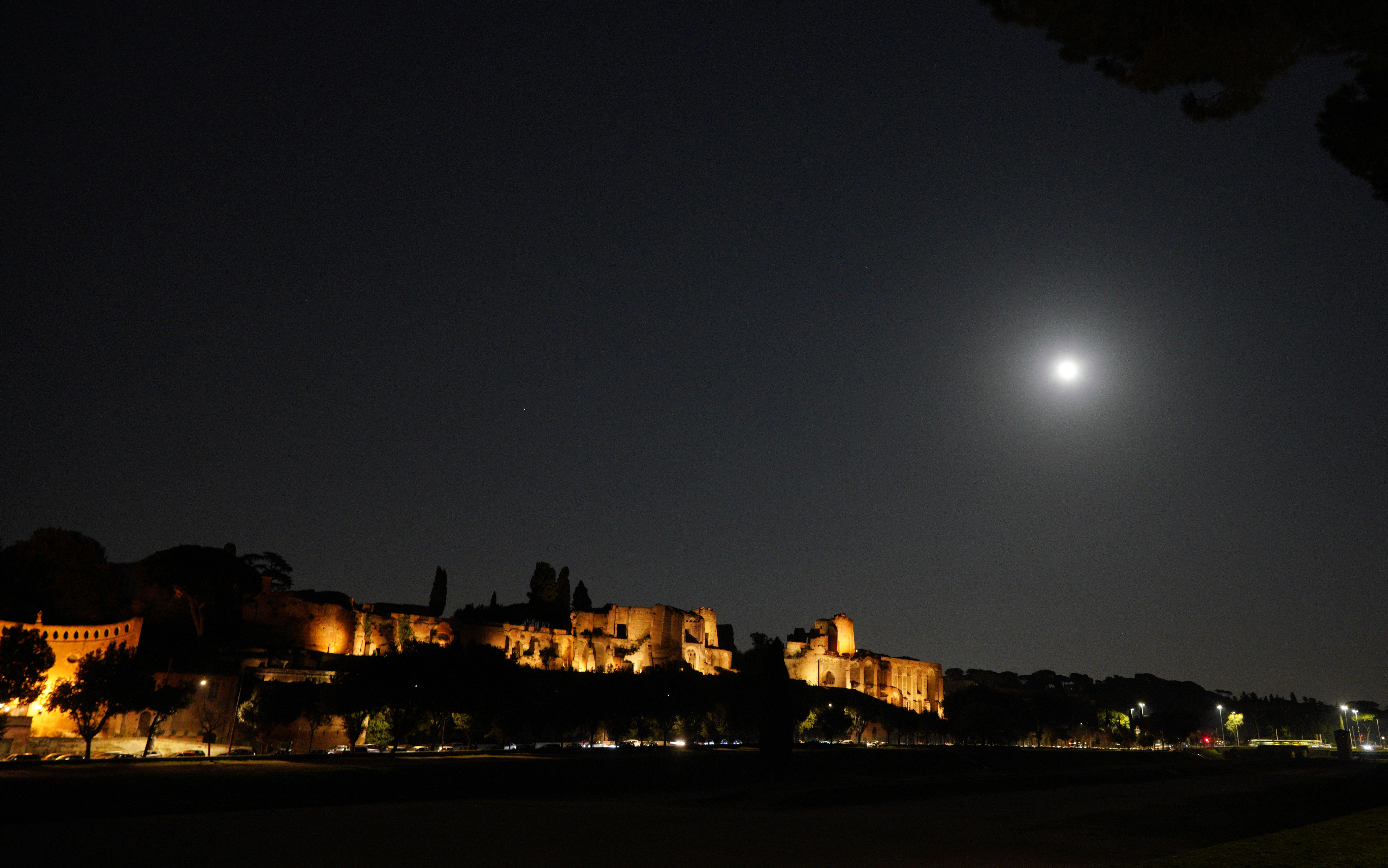 The moon shines over the Roman Forum in Rome Thursday, March 21, 2019. (AP Photo/Andrew Medichini)