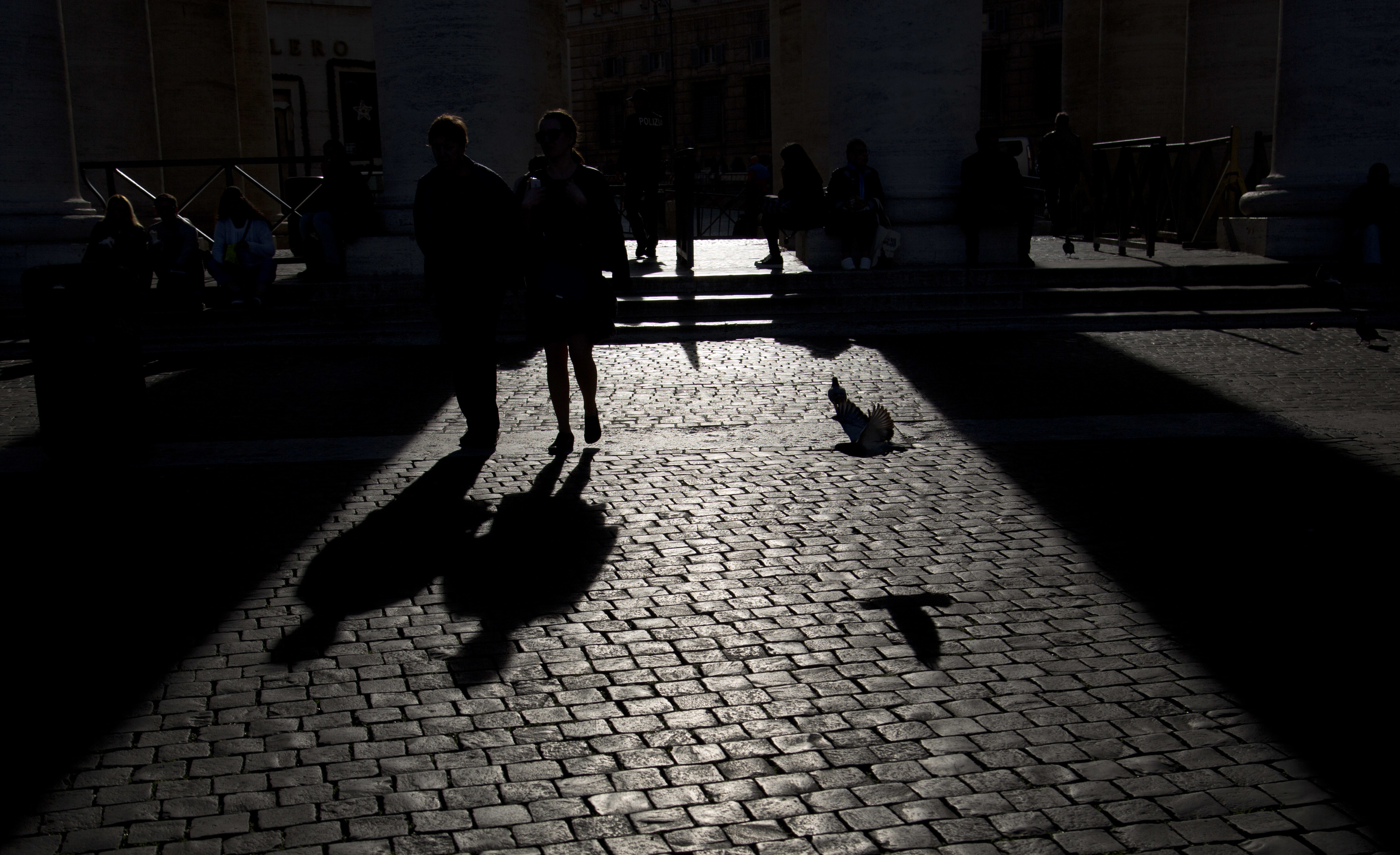 People cast their shadows on the cobblestones in St. Peter's Square at the Vatican, Thursday, Nov. 15, 2018. (AP Photo/Alessandra Tarantino)