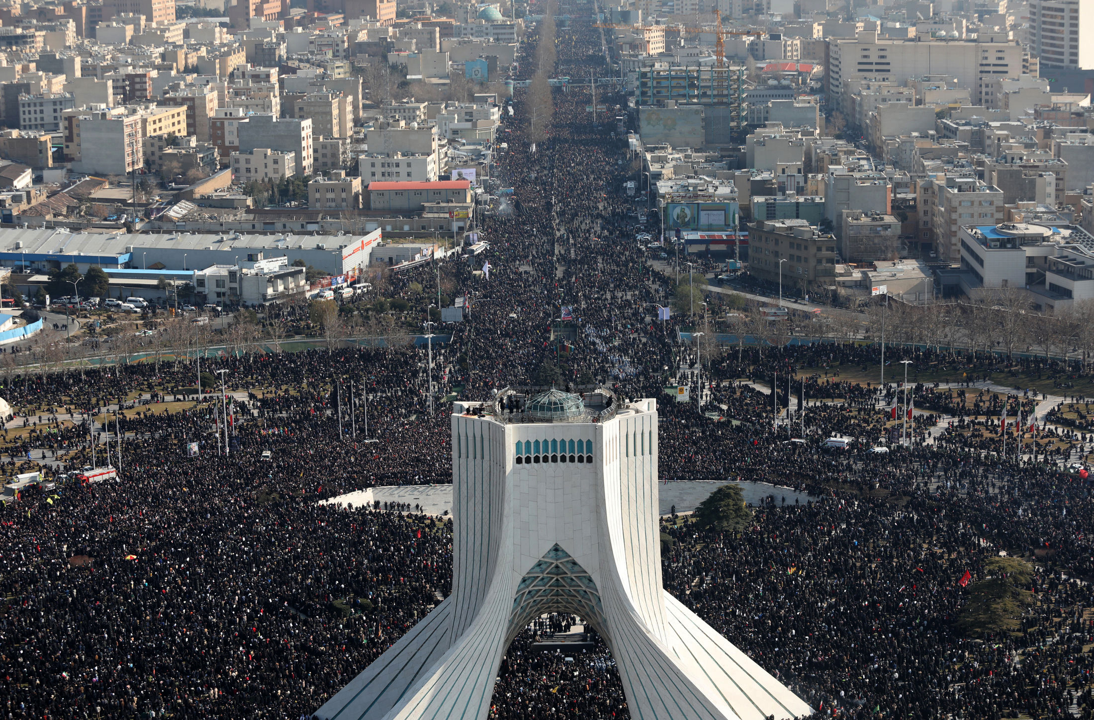 In this photo released by the official website of the Office of the Iranian Supreme Leader, mourners attend a funeral ceremony for Iranian Gen. Qassem Soleimani and his comrades, who were killed in Iraq in a U.S. drone attack on Friday, Jan. 3 as Azadi (freedom) tower is seen in the foreground, in Tehran, Iran, Monday, Jan. 6, 2020. The funeral for Soleimani drew a crowd said by police to be in the millions in the Iranian capital, filling thoroughfares and side streets as far as the eye could see. (Office of the Iranian Supreme Leader via AP)