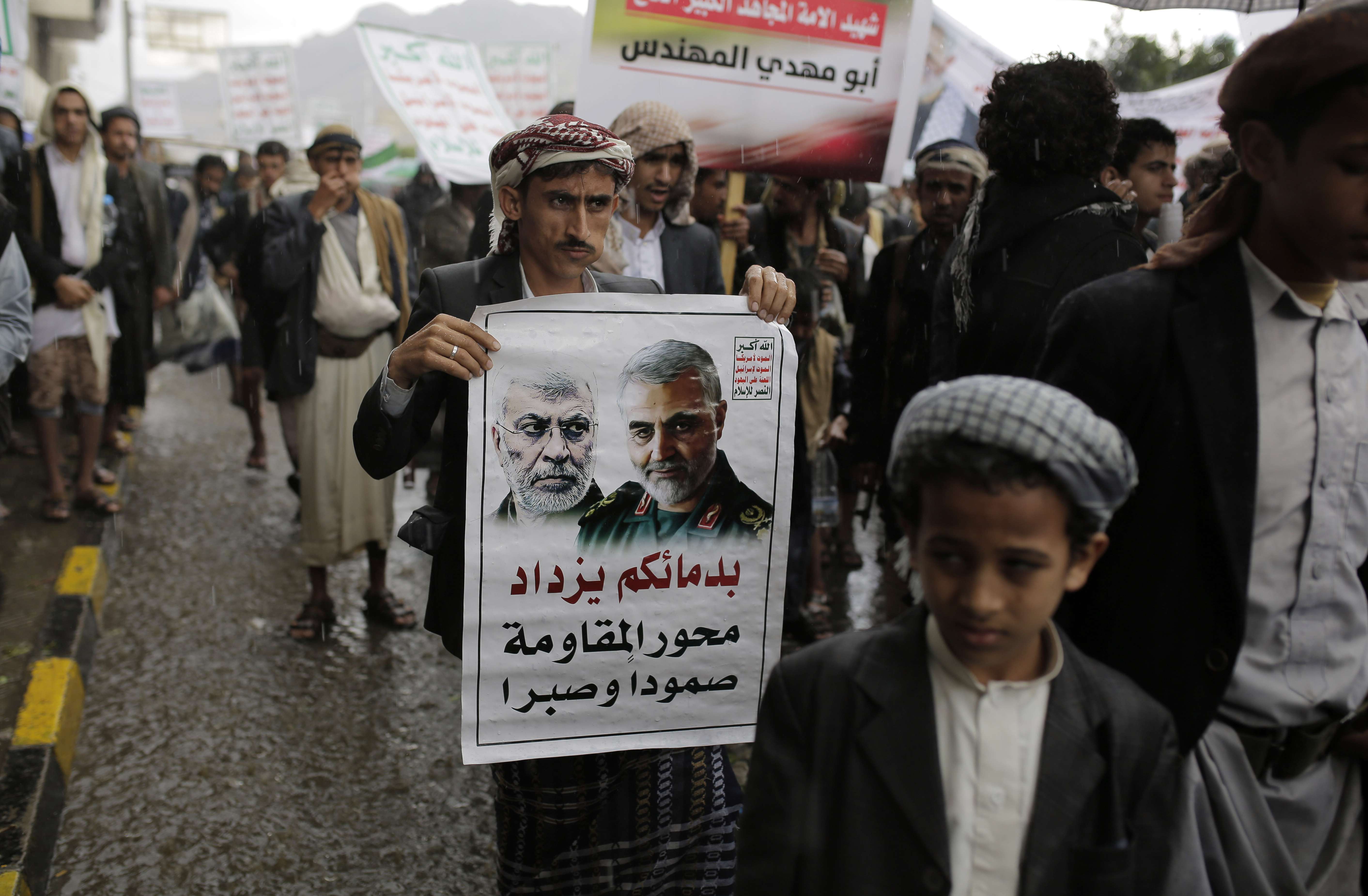 A Yemeni Shiite Houthi holds a poster of Iraqi militia commander Abu Mahdi al-Muhandis, left, and Iranian military commander Qassem Soleimani during a protest against a U.S. airstrike in Iraq that killed both commanders, in Sanaa, Yemen, Monday, Jan. 6, 2020. (AP Photo/Hani Mohammed)