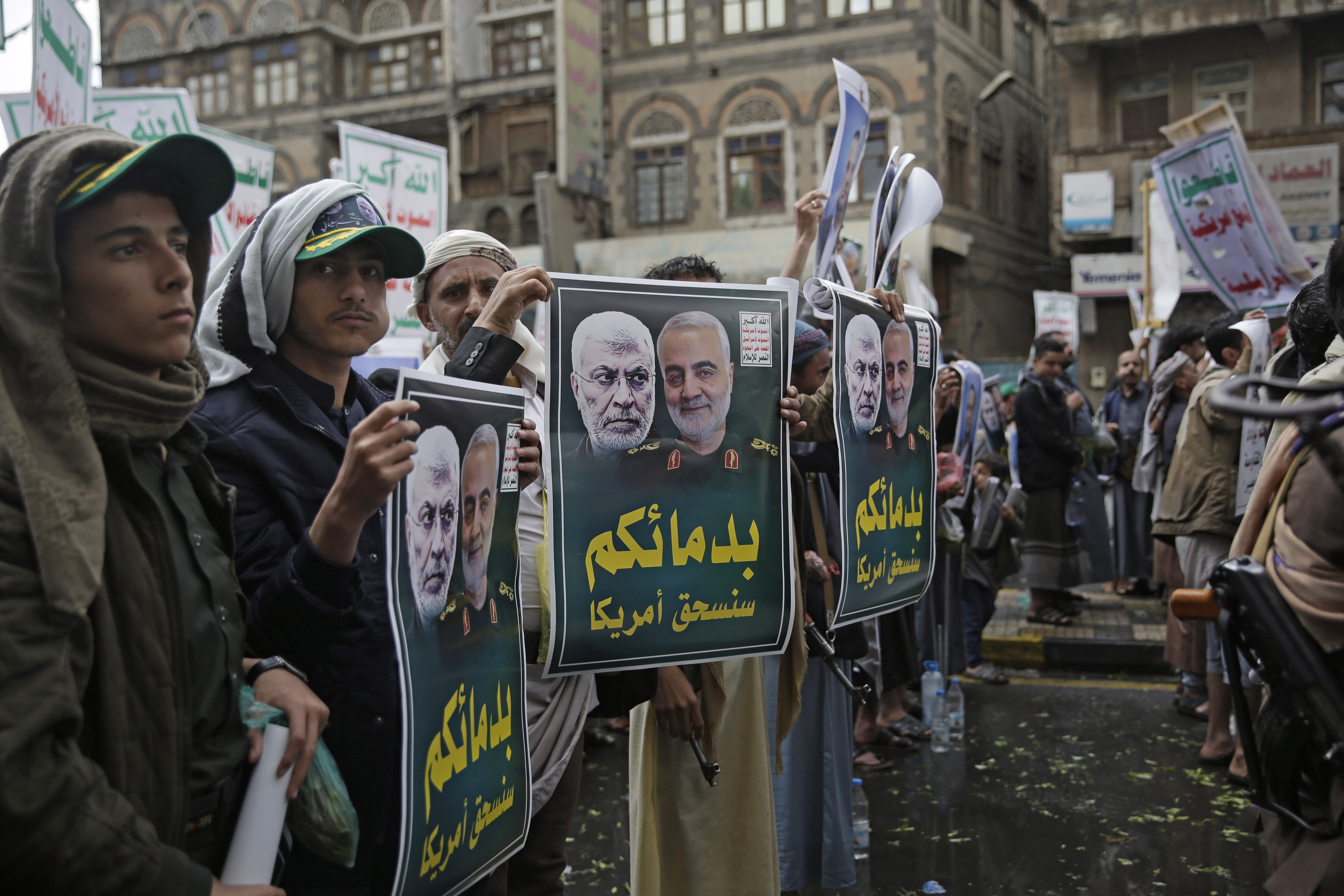 Yemeni Shiite Houthis hold posters of Iraqi militia commander Abu Mahdi al-Muhandis, left, and Iranian military commander Qassem Soleimani during a protest against a U.S. airstrike in Iraq that killed of both commanders, in Sanaa, Yemen, Monday, Jan. 6, 2020. Arabic writing on posters reads, 