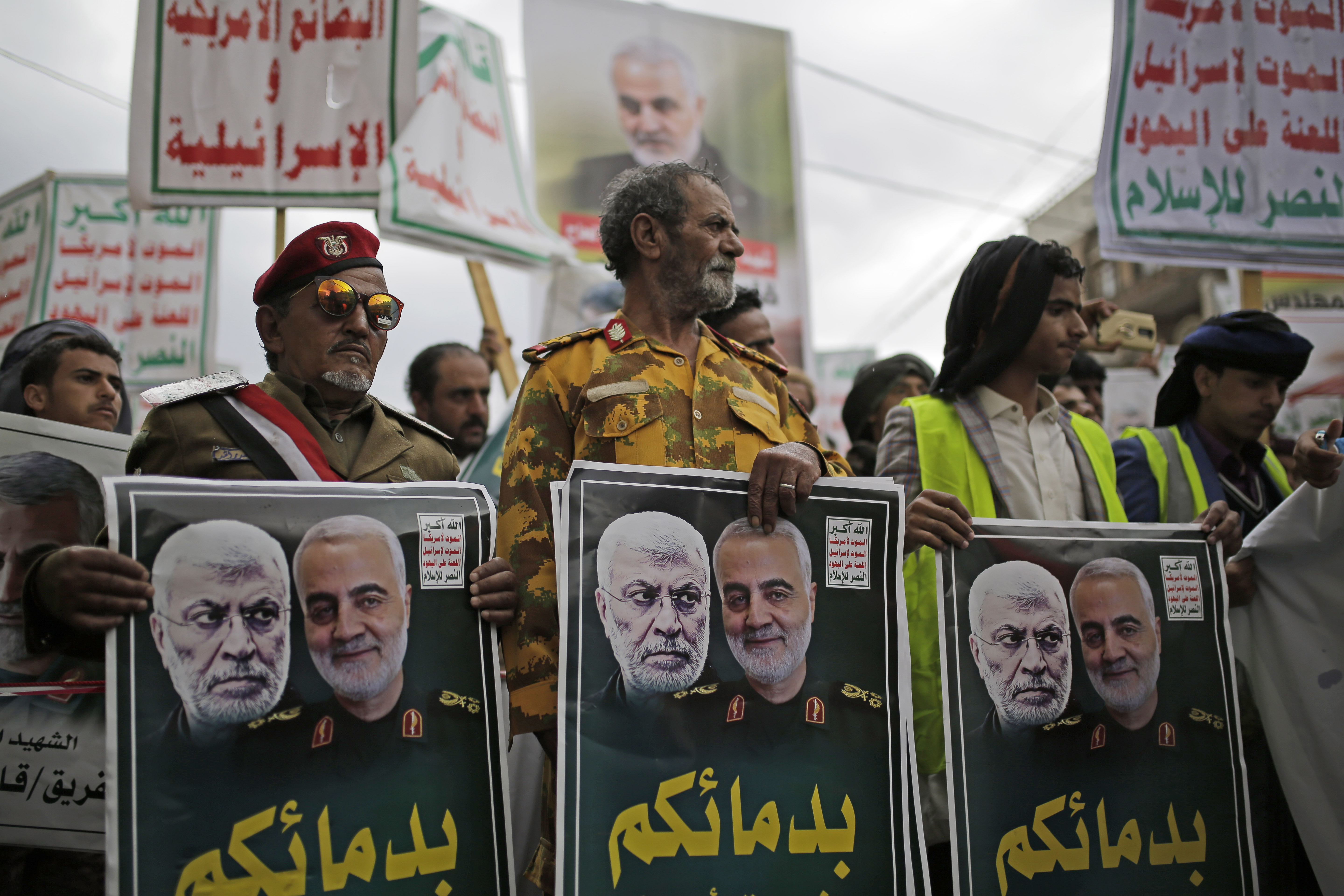 Yemeni Shiite Houthis hold posters of Iraqi militia commander Abu Mahdi al-Muhandis and Iranian military commander Qassem Soleimani during a protest against a U.S. airstrike in Iraq that killed them both, in Sanaa, Yemen, Monday, Jan. 6, 2020. Arabic writing on posters that reads, 