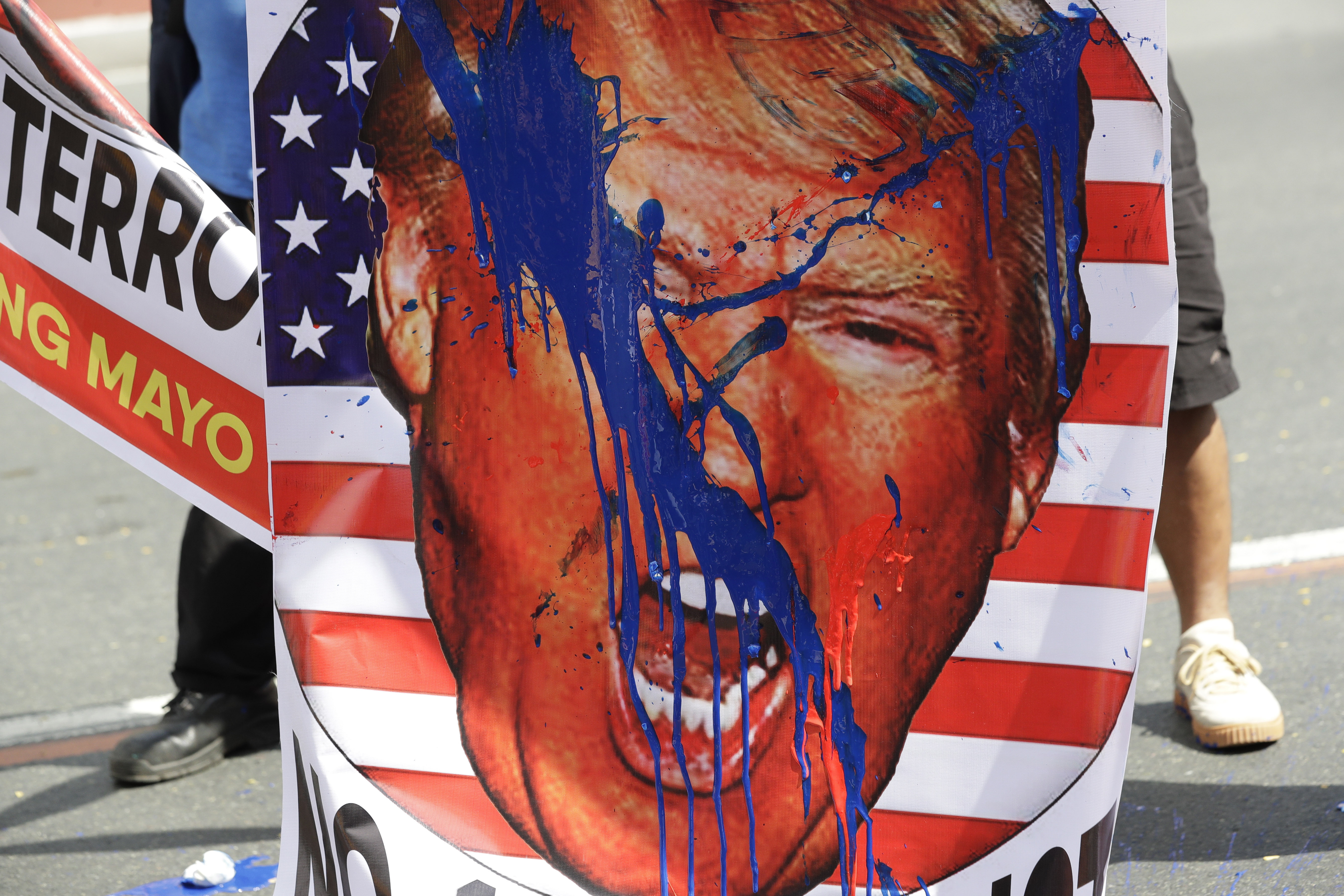 An image of U.S. President Donald Trump is splashed with paint by protesters as they hold a rally opposing the recent attack of the U.S. against Iran, where it killed Gen. Qassem Soleimani, near the U.S. Embassy in Manila, Philippines, Monday, Jan. 6, 2020. Philippine President Rodrigo Duterte ordered the military to prepare to deploy its aircraft and ships 