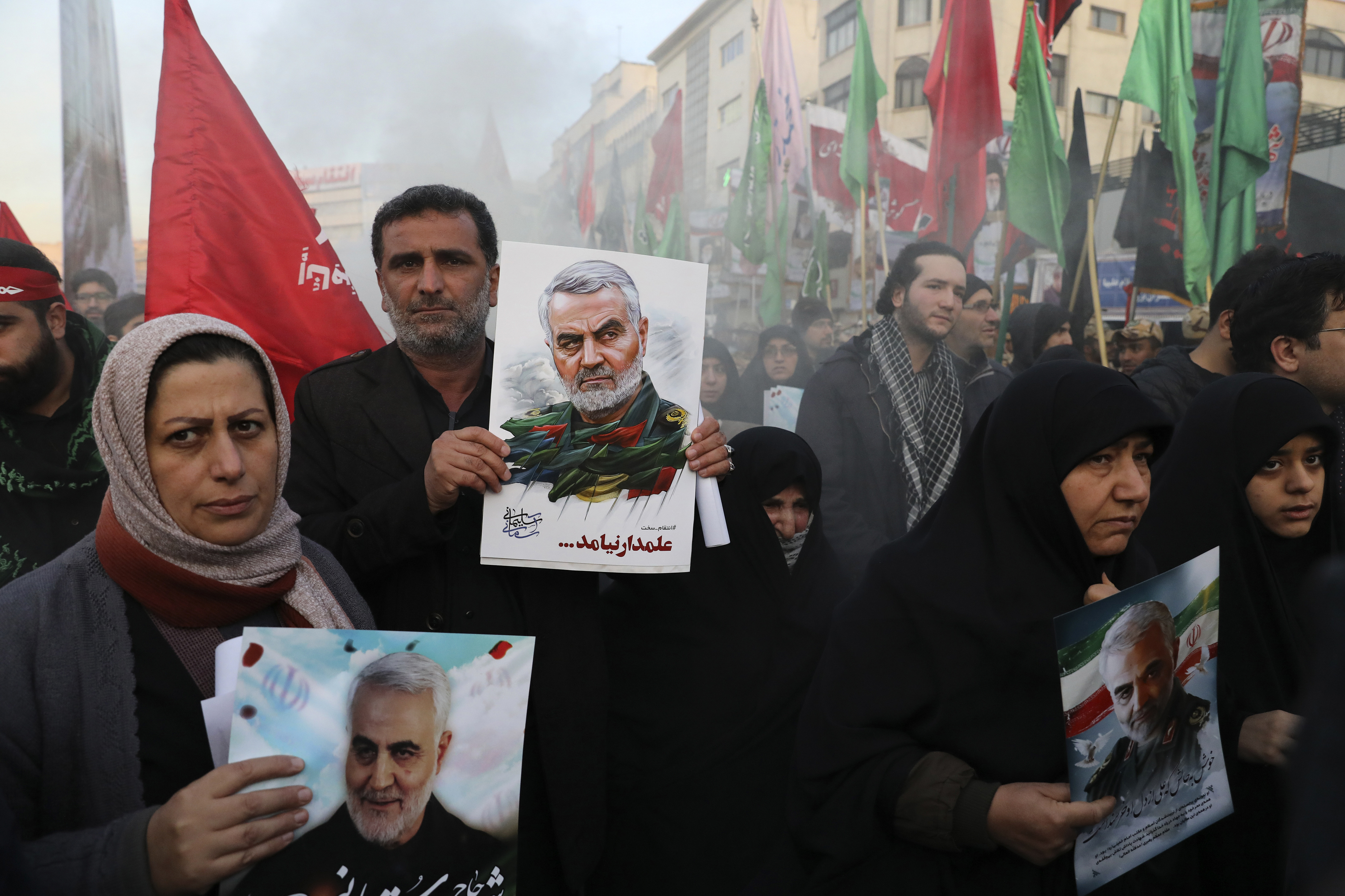 Mourners holding posters of Iranian Gen. Qassem Soleimani attend a funeral ceremony for him and his comrades, who were killed in Iraq in a U.S. drone strike on Friday, at the Enqelab-e-Eslami (Islamic Revolution) Square in Tehran, Iran, Monday, Jan. 6, 2020. (AP Photo/Ebrahim Noroozi)
