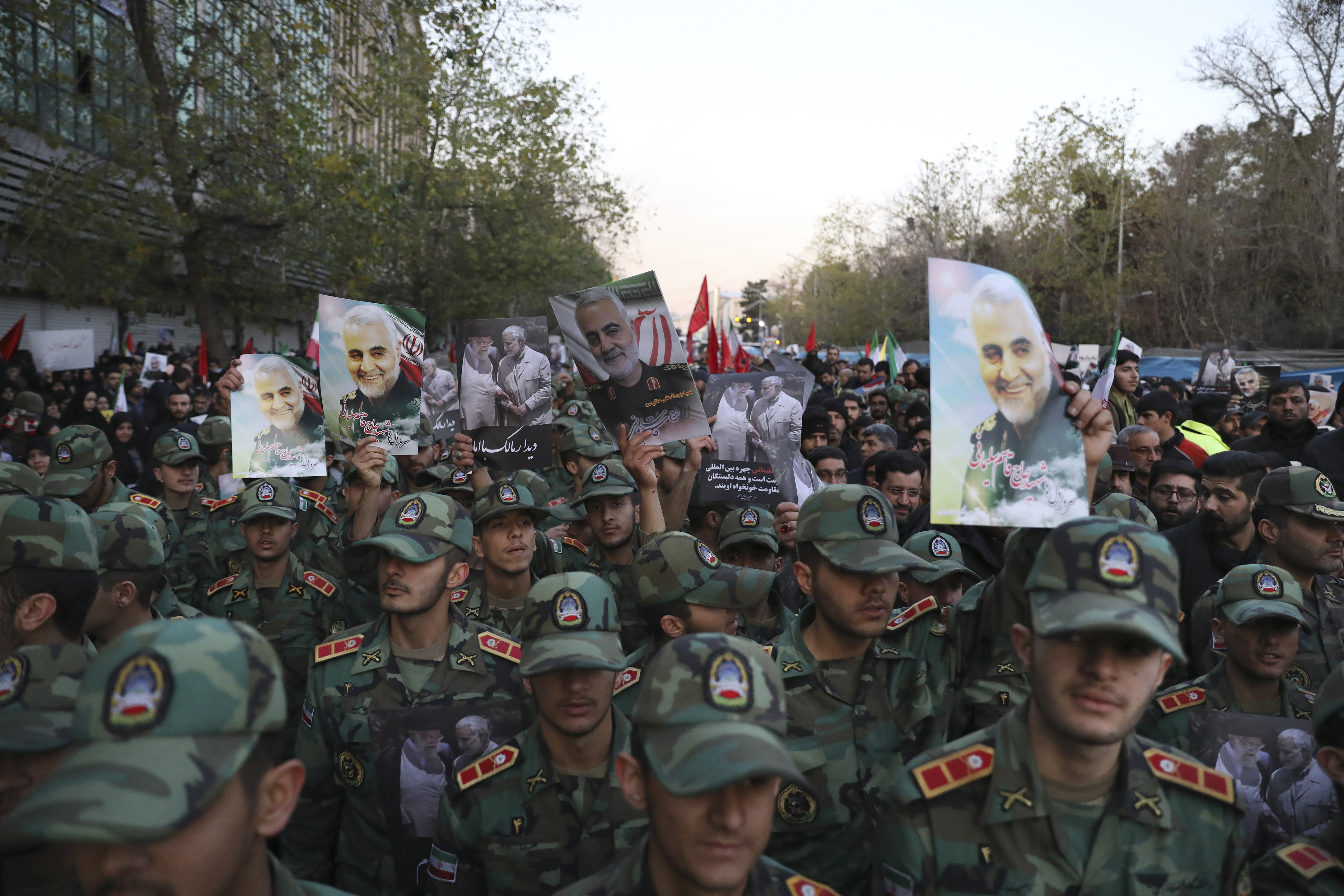 Army cadets attend a funeral ceremony for Iranian Gen. Qassem Soleimani, shown in posters, and his comrades, who were killed in Iraq in a U.S. drone strike on Friday, at the Enqelab-e-Eslami (Islamic Revolution) square in Tehran, Iran, Monday, Jan. 6, 2020. (AP Photo/Ebrahim Noroozi)