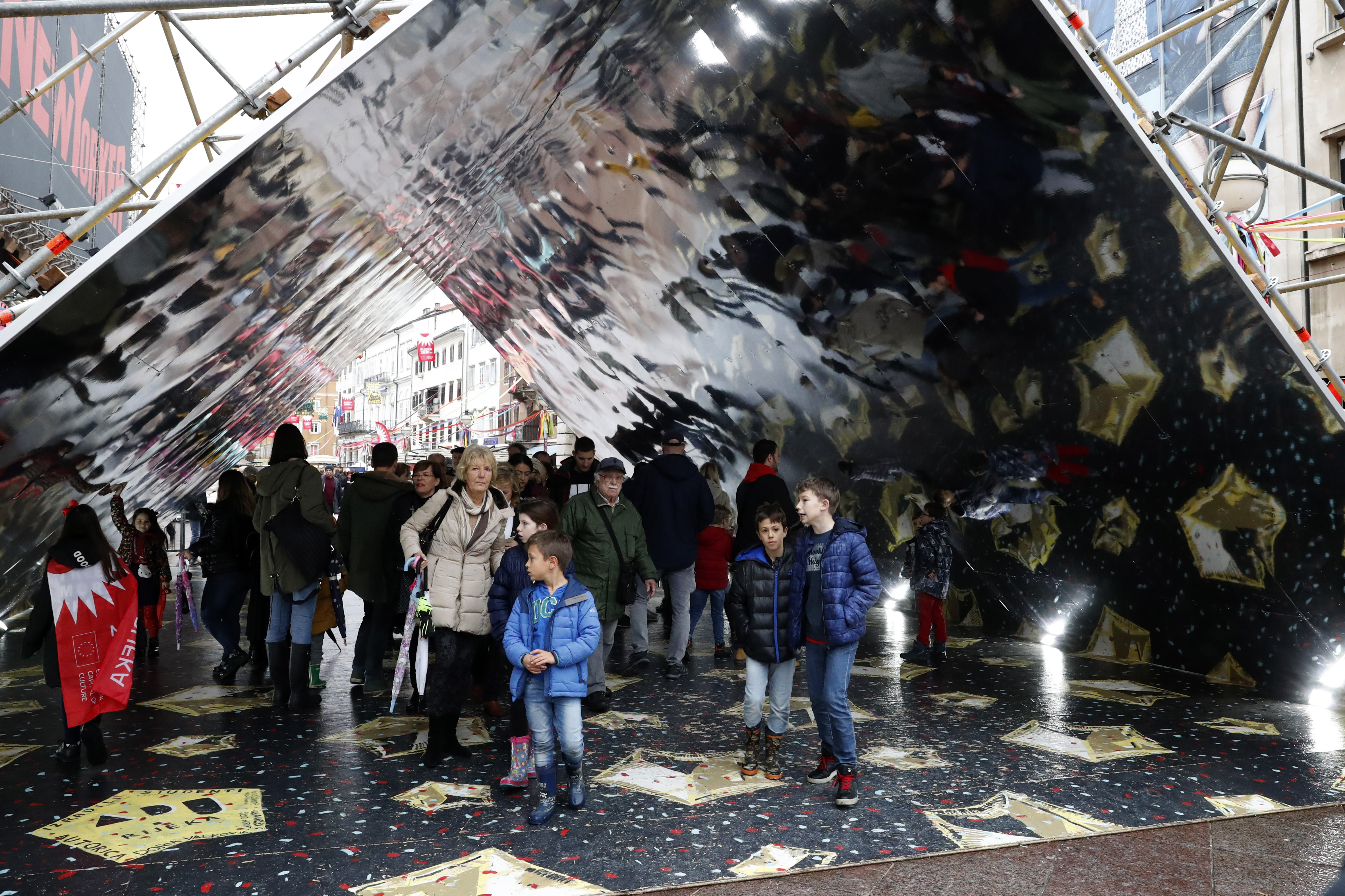 Visitors walk through a giant kaleidoscope in downtown Rijeka, Croatia, Saturday, Feb. 1, 2020. Adriatic port city of Rijeka is European Capital of Culture designated by the European Union for the year 2020, during which a series of cultural events with a strong pan-European dimension will be organized. (AP Photo/Darko Bandic)