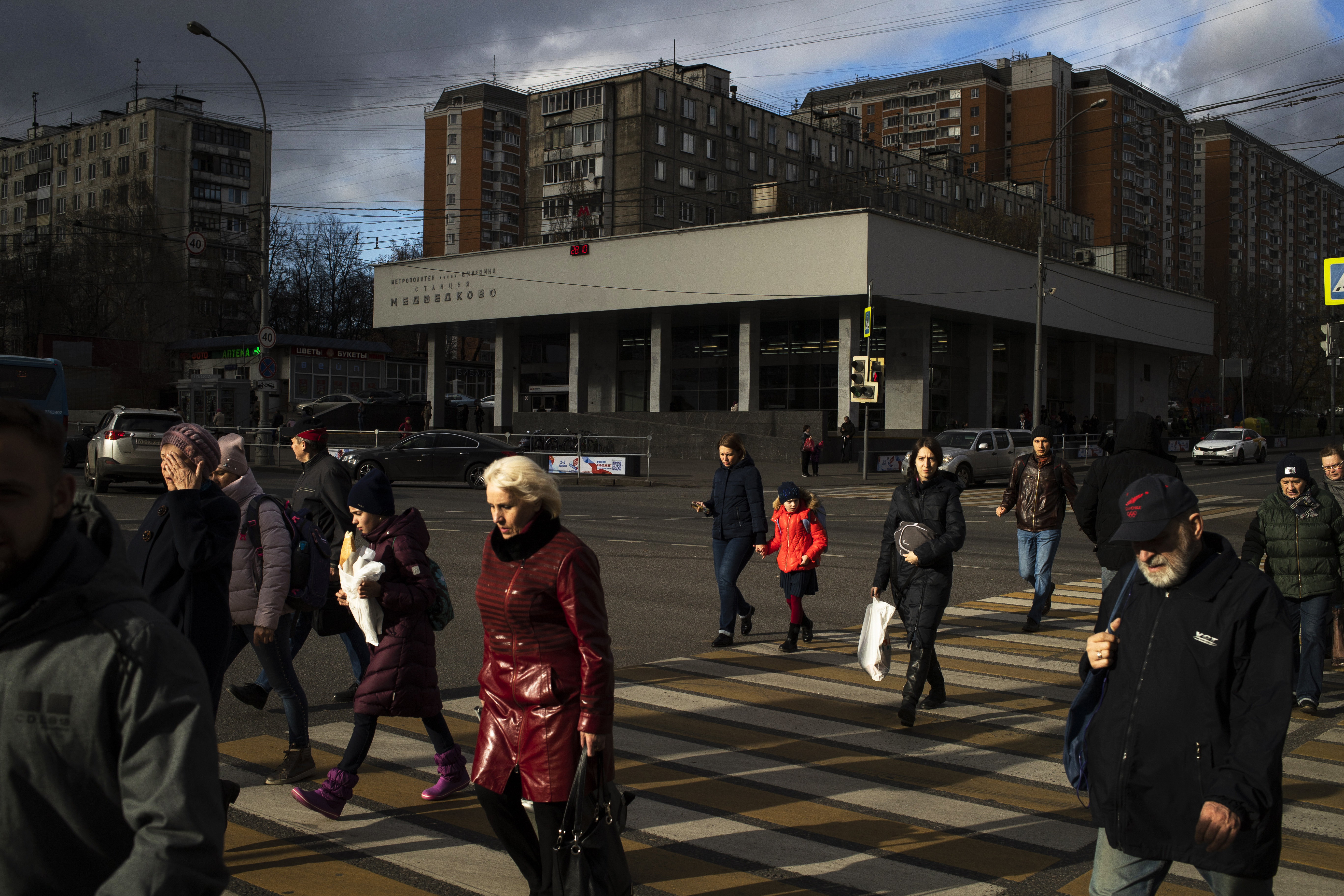 People cross a street on a sunny autumn day in Moscow, Russia, Monday Oct. 28, 2019. (AP Photo/Pavel Golovkin)