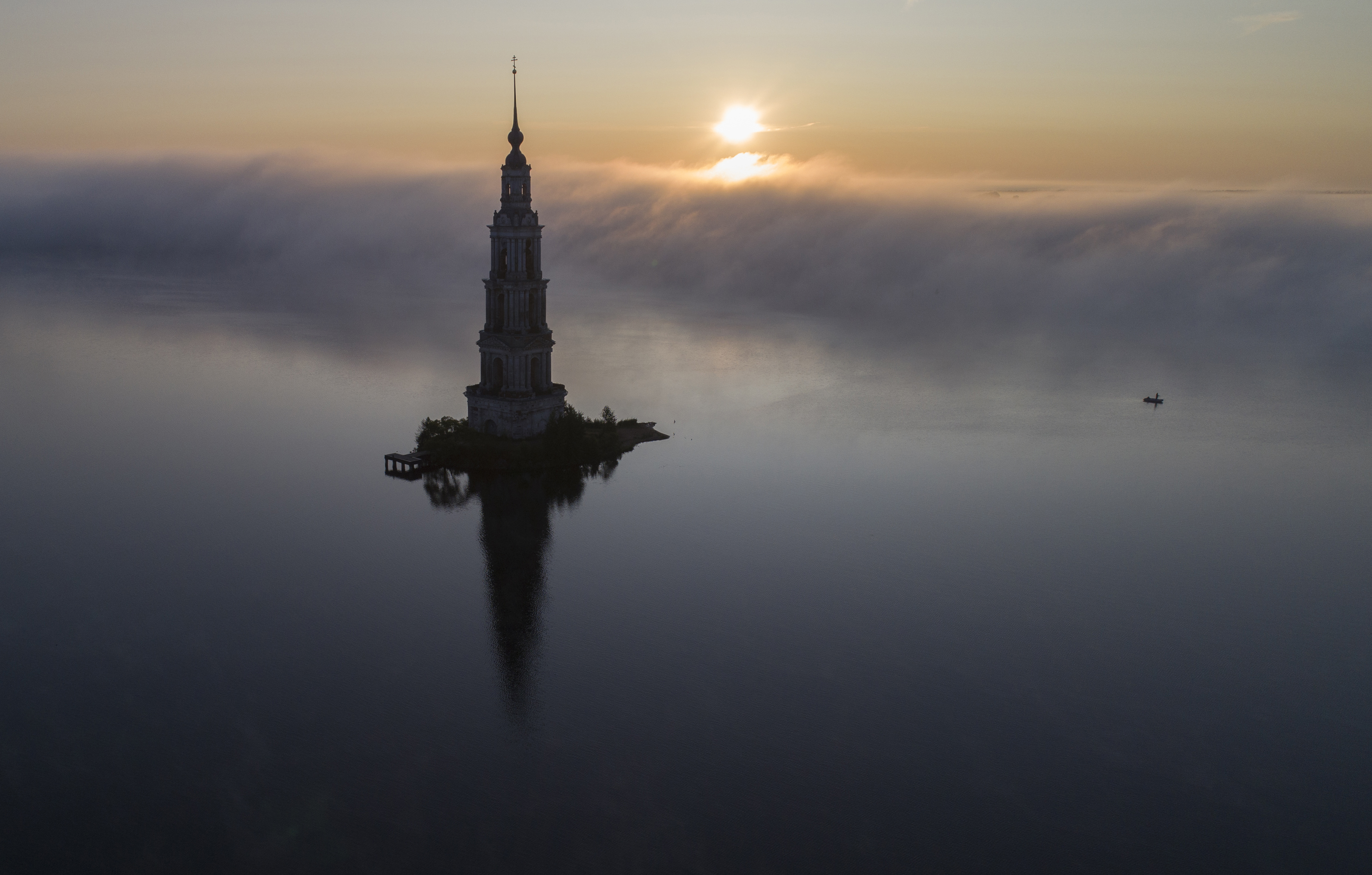 The famous Kalyazin Bell Tower, part of the submerged monastery of St. Nicholas, is seen in the morning fog in the town of Kalyazin located on the Volga River, 180 km (111 miles) north-east of Moscow, Russia, Monday, Aug. 12, 2019. After the construction of the Uglich Dam in 1939 to form the Uglich Reservoir, the old parts of Kalyazin, including several medieval structures, were submerged under the reservoir's waters. (AP Photo/Dmitri Lovetsky)