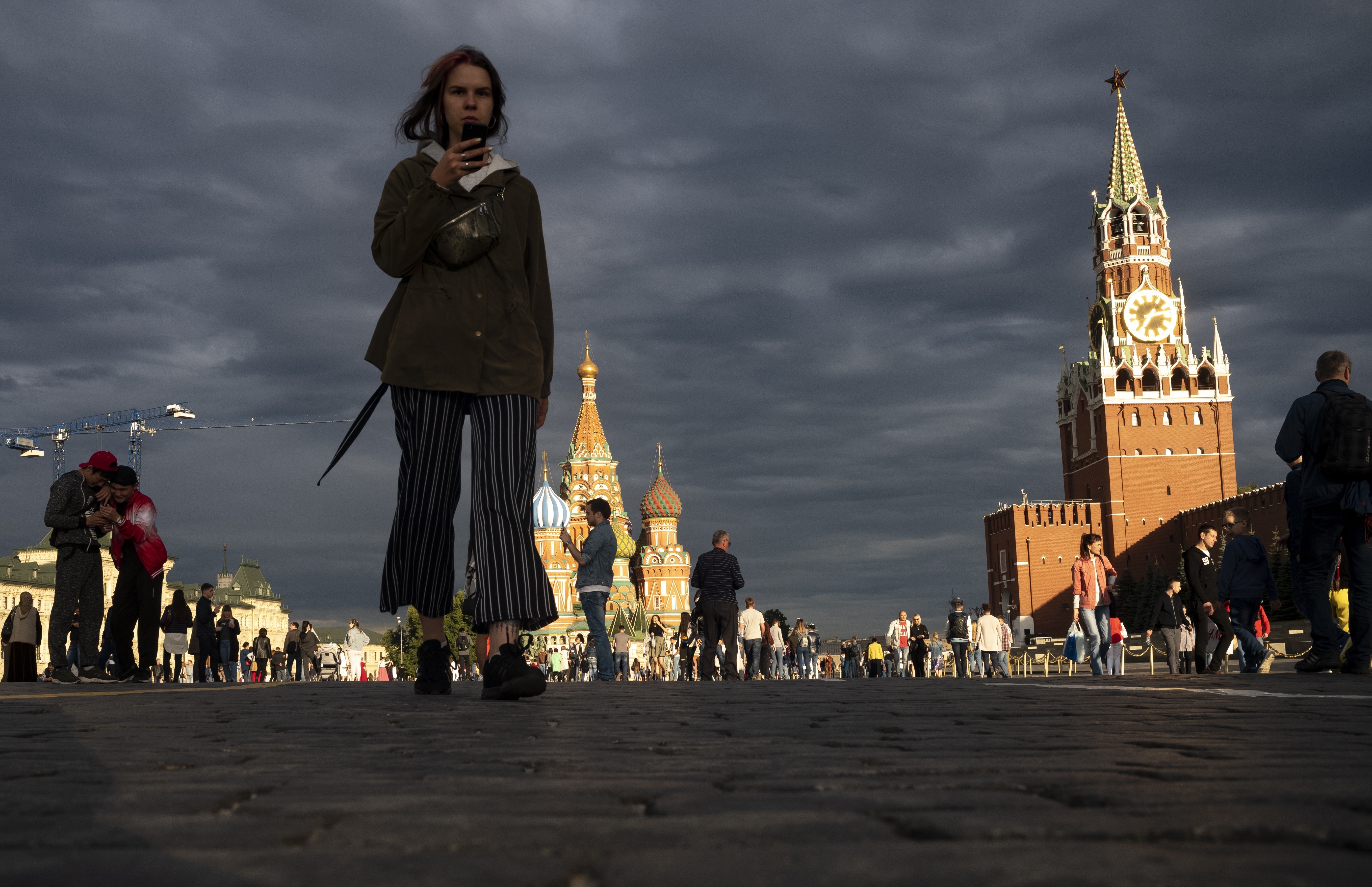 A woman walks through Red Square during sunset in Moscow, Russia, Sunday, July 7, 2019. The temperature in Moscow has dropped to 20 degrees Celsius. (AP Photo/Alexander Zemlianichenko)