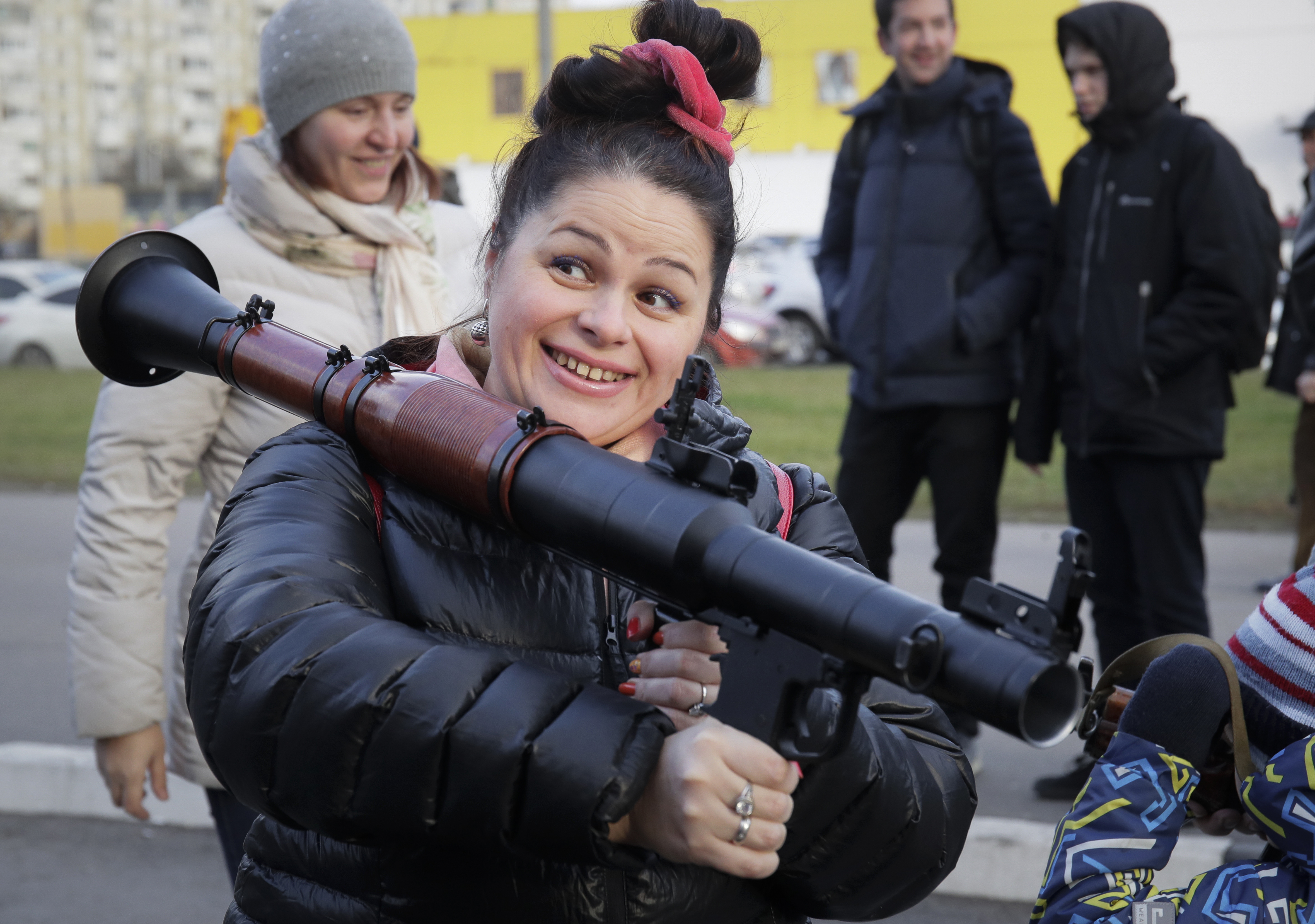 A woman poses with a grenade launcher at a weapons exhibition during festivities marking Marines Day in St.Petersburg, Russia, Saturday, Nov. 24, 2018. (AP Photo/Dmitri Lovetsky)