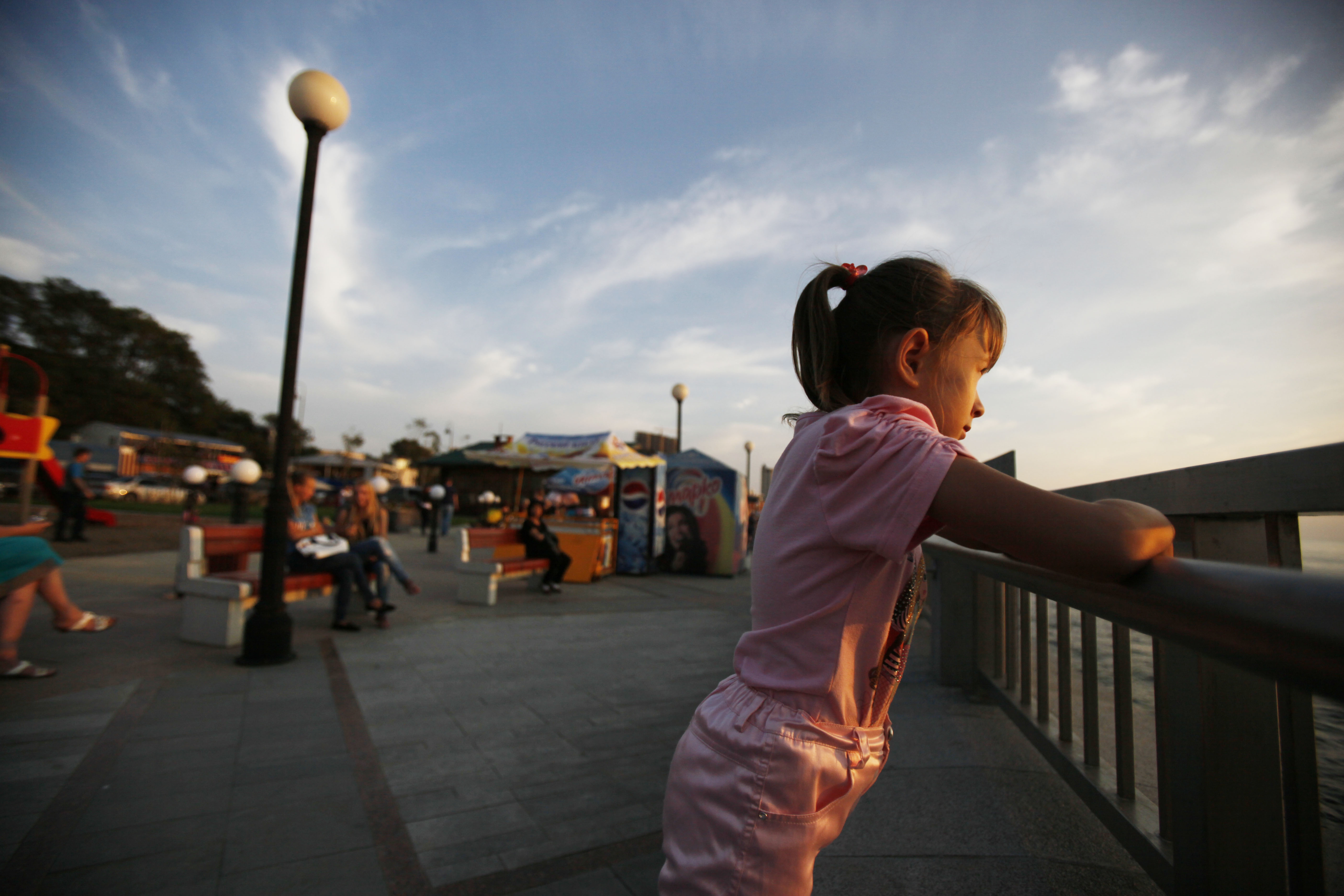 A young girl looks out from a waterfront walkway in Vladivostok, Russia, Monday, Sept. 10, 2012. (AP Photo/Greg Baker)