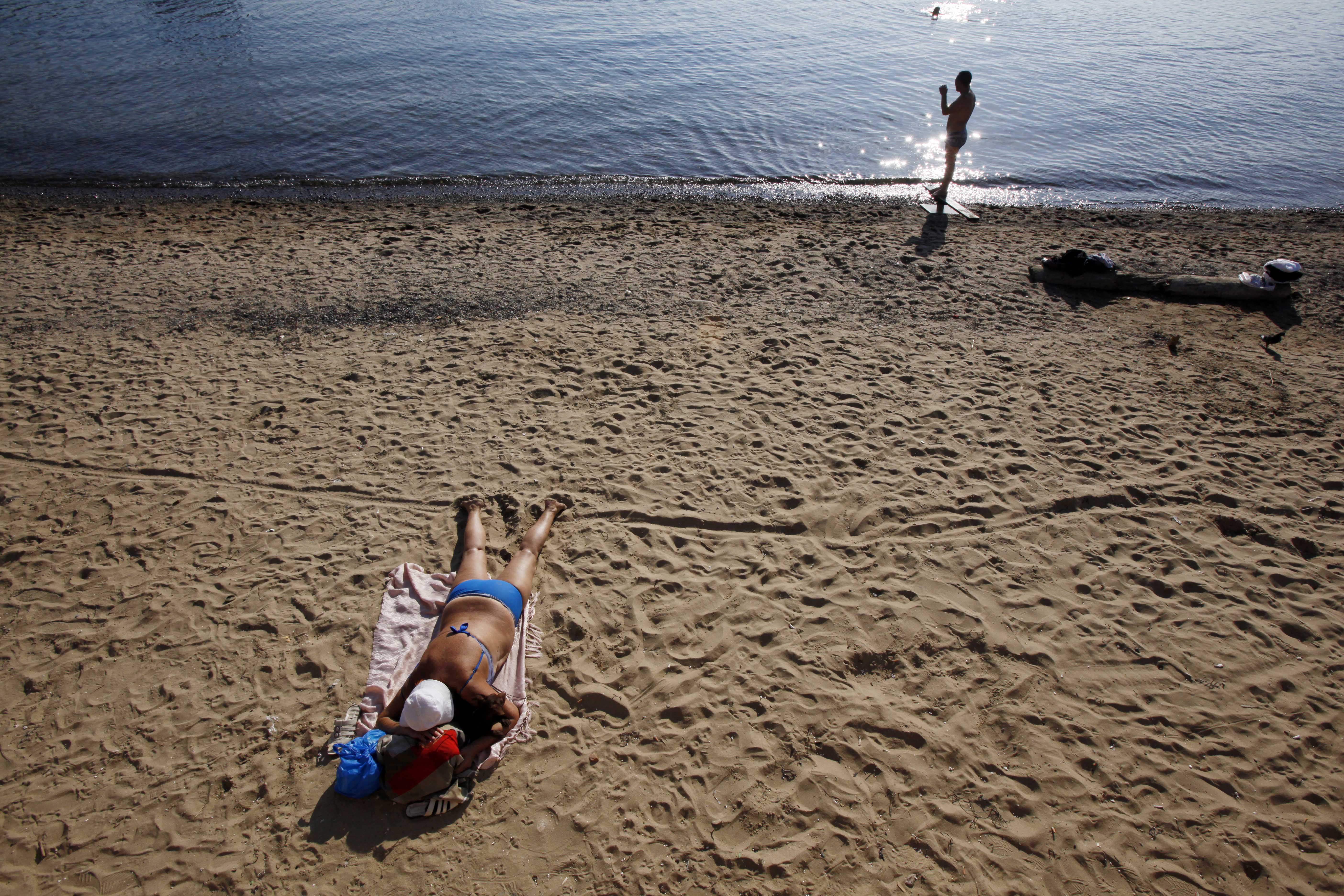 A woman sunbathes on a beach in Vladivostok, Russia, Monday, Sept. 10, 2012. (AP Photo/Greg Baker)