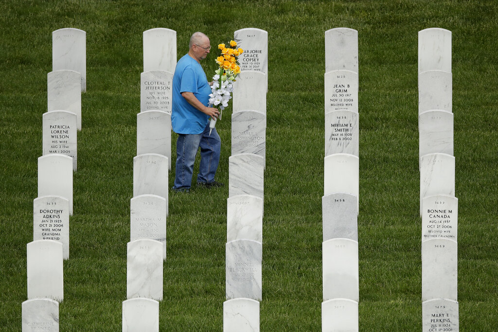 A man looks for a grave while visiting Leavenworth National Cemetery Saturday, May 23, 2020 in Leavenworth, Kan. Several people said they made their annual visit to the cemetery today instead of Memorial Day to beat the crowd and minimize the chance of catching COVID-19. (AP Photo/Charlie Riedel)