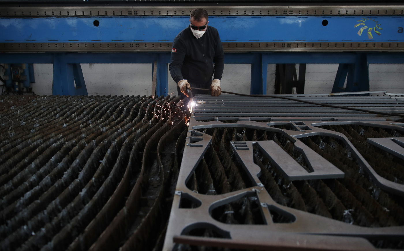 A man works at MAP, a factory operating in design, manufacture and installation of steel structures for civil and industrial use, in Corsico, near Milan, Italy, Wednesday, May 6, 2020. Italy began stirring again after the coronavirus shutdown, with 4.4 million Italians able to return to work and restrictions on movement eased in the first European country to lock down in a bid to stem COVID-19 infections. (AP Photo/Antonio Calanni)