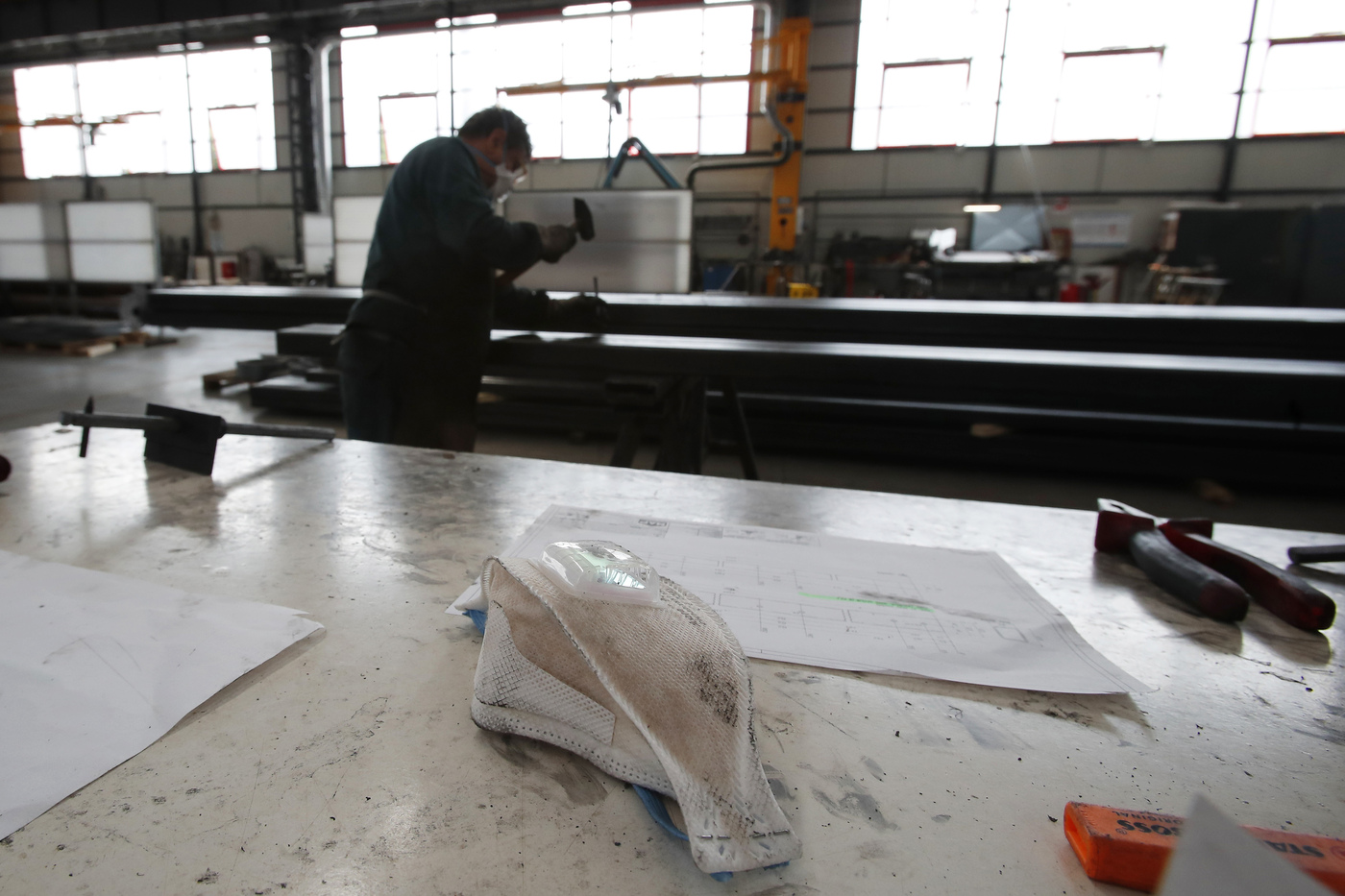 A safety mask lies on he table along with other instruments at MAP, a factory operating in design, manufacture and installation of steel structures for civil and industrial use, in Corsico, near Milan, Italy, Wednesday, May 6, 2020. Italy began stirring again after the coronavirus shutdown, with 4.4 million Italians able to return to work and restrictions on movement eased in the first European country to lock down in a bid to stem COVID-19 infections. (AP Photo/Antonio Calanni)