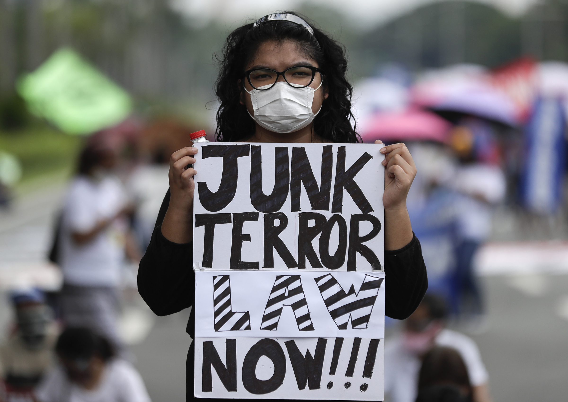 A protester holds a slogan during a rally against the anti-terror law at the University of the Philippines in Manila, Philippines on Tuesday July 7, 2020. Philippine President Rodrigo Duterte recently signed a widely opposed anti-terror law which critics fear could be used against human rights defenders and to muzzle dissent. (AP Photo/Aaron Favila)