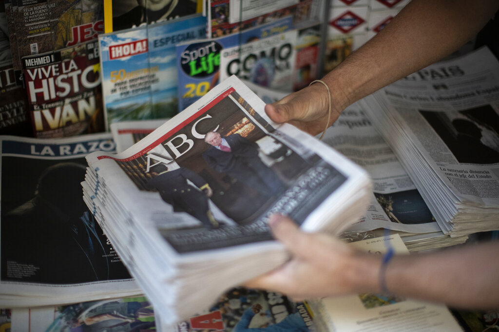 Front pages of newspapers are displayed with the news of Spain's former monarch, King Juan Carlos I in Madrid, Spain, Tuesday, Aug. 4, 2020. Speculation over the whereabouts of the former monarch is gripping Spain, a day after he announced he was leaving the country for an unspecified destination amid a growing financial scandal. (AP Photo/Manu Fernandez)