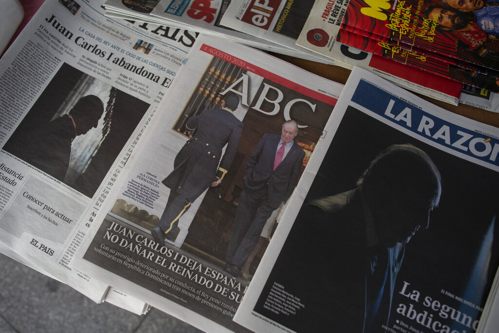 Front pages of newspapers are displayed with the news on Spain's former monarch, King Juan Carlos I, in Madrid, Spain, Tuesday, Aug. 4, 2020. Speculation over the whereabouts of former monarch Juan Carlos is gripping Spain, a day after he announced he was leaving the country for an unspecified destination amid a growing financial scandal. (AP Photo/Manu Fernandez)