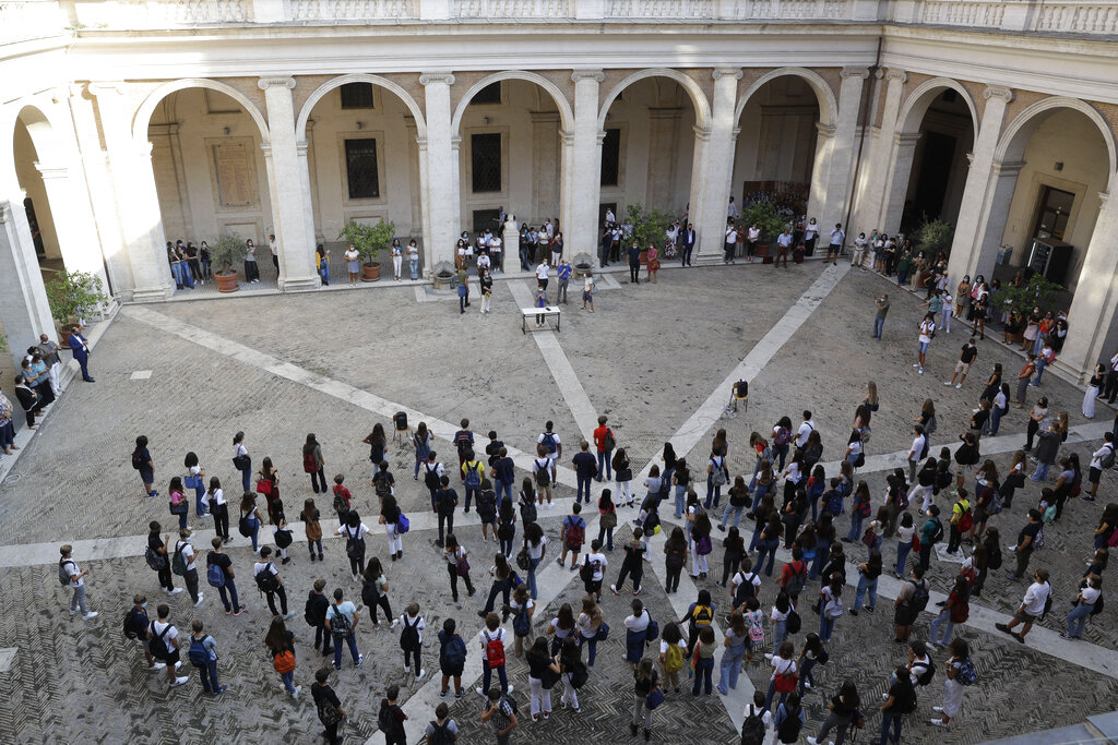 Students gather in the courtyard as they attend a welcome ceremony at the Visconti high school, in Rome, Monday, Sept. 14, 2020. The reopening of Italian schools marks an important step in a return to pre-lockdown routine after six long months, long after the buzz returned to shopping malls, theaters and beaches, and another test of the government’s management of the pandemic. Italian schools closed nationwide on March 5 and never reopened as Italy became the epicenter of the pandemic in Europe. (AP Photo/Gregorio Borgia)