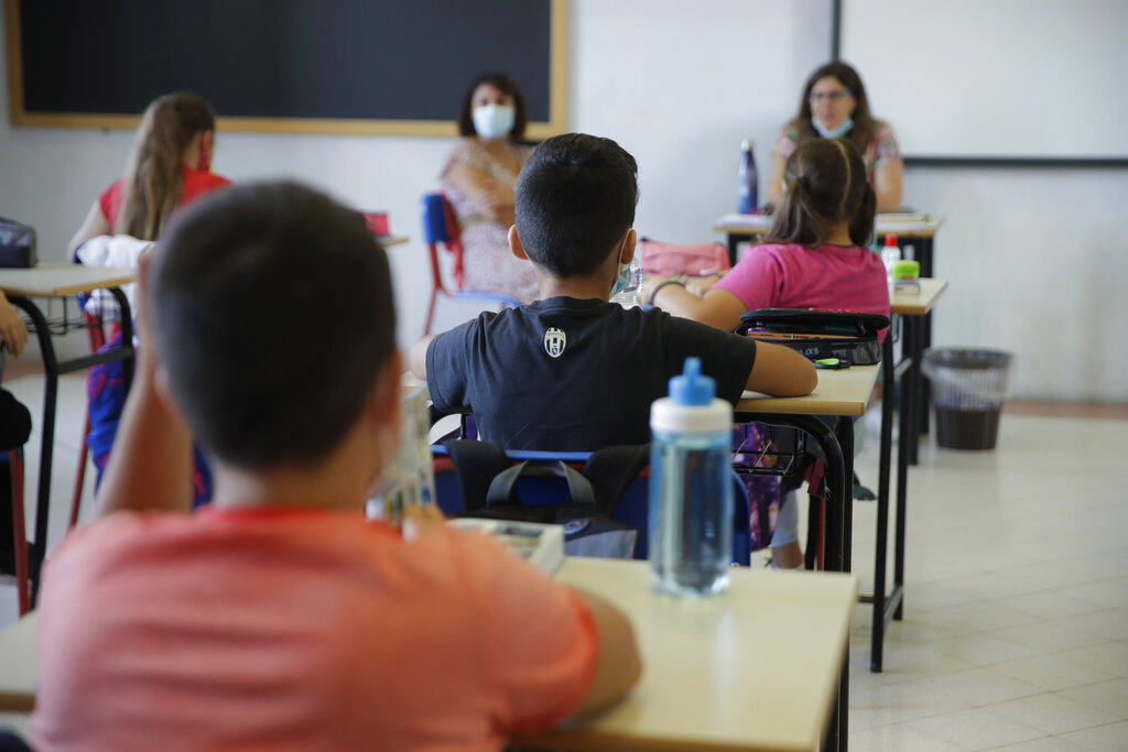 Students sit in their classroom at the San Biagio primary school in Codogno, Italy, Monday, Sept. 14, 2020. The morning bell Monday marks the first entrance to the classroom for the children of Codogno since Feb. 21,  when panicked parents were sent to pick up their children after the northern Italian town gained notoriety as the first in the West to record local transmission of the coronavirus. (AP Photo/Luca Bruno)