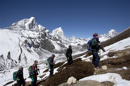 FILE - In this March 18, 2015 file photo, trekkers take an acclimatization hike to Nagarzhang peak above Dingboche valley on the way to Everest base camp, Nepal. Mohan Sapkota, a spokesman for the Himalayan country's ministry of tourism said Tuesday, Sept. 29, 2015, that Nepal is considering placing age and fitness limits for people who want to climb Mount Everest. Last week Japanese climber Nobukazu Kuriki, who had lost nine fingers to frostbite, abandoned his fifth unsuccessful attempt to scale Everest. Everest climbing permits earn the impoverished nation millions of dollars but the government has come under criticism after a series of disasters over the last few years. (AP Photo/Tashi Sherpa, file)