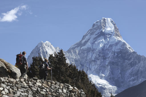 FILE - In this Feb. 19, 2016, file photo, trekkers make their way to Dingboche, a popular Mount Everest base camp, in Pangboche, Nepal. Nepal celebrated Everest Day on Sunday, May 29, 2016, by honoring nine Sherpa guides who fixed ropes and dug the route to the summit so hundreds of climbers could scale the worlds highest mountain this month, following two years of disasters. (AP Photo/Tashi Sherpa, File)