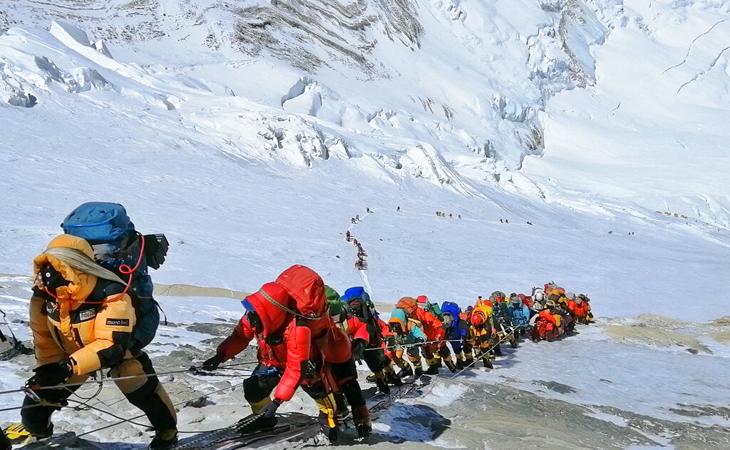 FILE - In this May 22, 2019, file photo, a long queue of mountain climbers line a path on Mount Everest just below camp four, in Nepal. Expedition operators on Mount Everest say that Chinese mountaineering officials will not allow spring climbs from their side of the mountain due to fears of the coronavirus. (AP Photo/Rizza Alee, File)