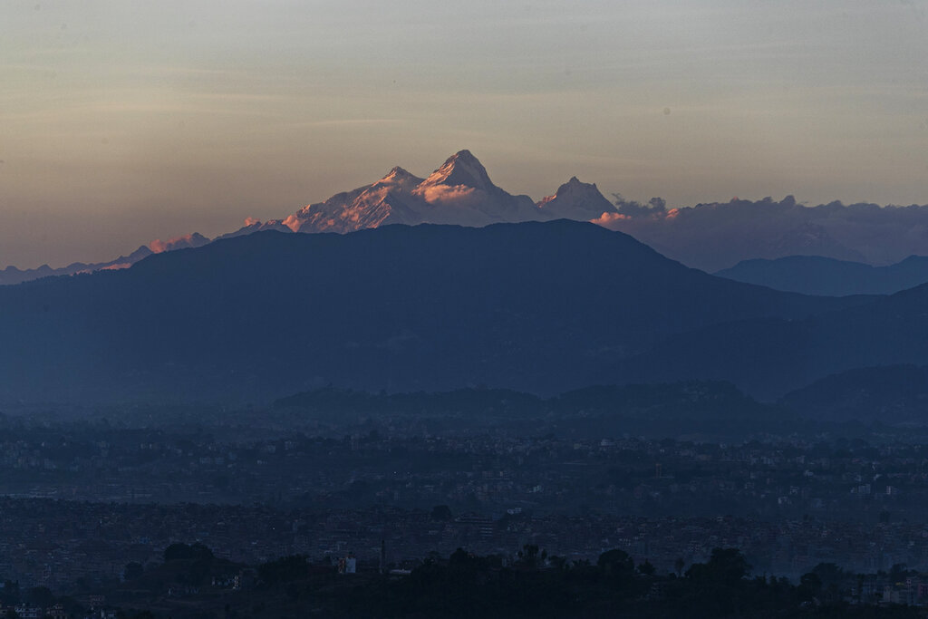 Himalchuli mountain, center and the Manasulu Mountain range, right is seen from Bhaktapur, Nepal  Saturday, Oct 31, 2020. Nepal has reopened its peaks and trails for foreign adventurers in hopes of providing much needed income for hundreds of thousands of guides, porters and workers who have been unemployed for months because of the pandemic. (AP Photo/Niranjan Shrestha)