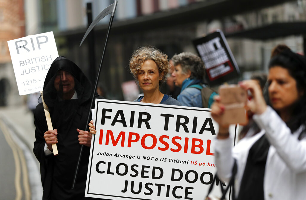 Protesters stand opposite the Central Criminal Court, the Old Bailey, in London, Monday, Sept. 21, 2020, as the Julian Assange extradition hearing to the US continues. (AP Photo/Frank Augstein)