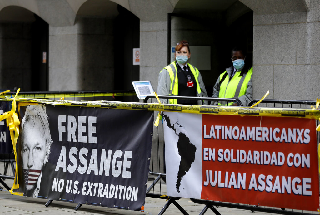 Banners are tied to railings as security officers stand outside the Old Bailey in London, Thursday, Oct. 1, 2020, as the Julian Assange extradition hearing to the US continues. (AP Photo/Kirsty Wigglesworth)