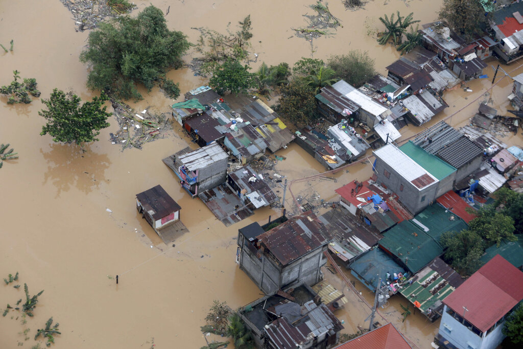 In this photo provided by the Malacanang Presidential Photographers Division, houses are surrounded by floodwaters brought by Typhoon Vamco in Metro Manila, Philippines, Thursday Nov. 12, 2020. Typhoon Vamco swelled rivers and flooded low-lying areas as it passed over the storm-battered northeast Philippines, where rescuers were deployed early Thursday to help people flee the rising waters. (Ace Morandante/ Malacanang Presidential Photographers Division via AP)