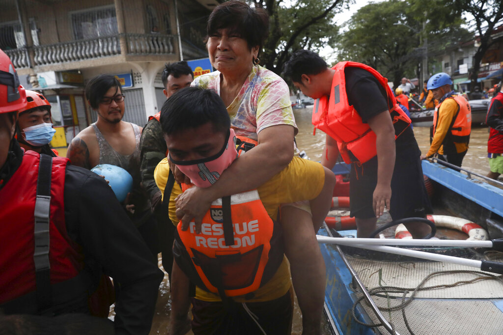 A rescuer carries a woman out from a rubber boat during a mass evacuation as flood waters rise in Marikina River due to Typhoon Vamco in Providence village in Marikina City, east of Manila, Philippines, Thursday. Nov. 12, 2020. The typhoon swelled rivers and flooded low-lying areas as it passed over the storm-battered northeast Philippines, where rescuers were deployed early Thursday to help people flee the rising waters. (AP Photo/Basilio Sepe)