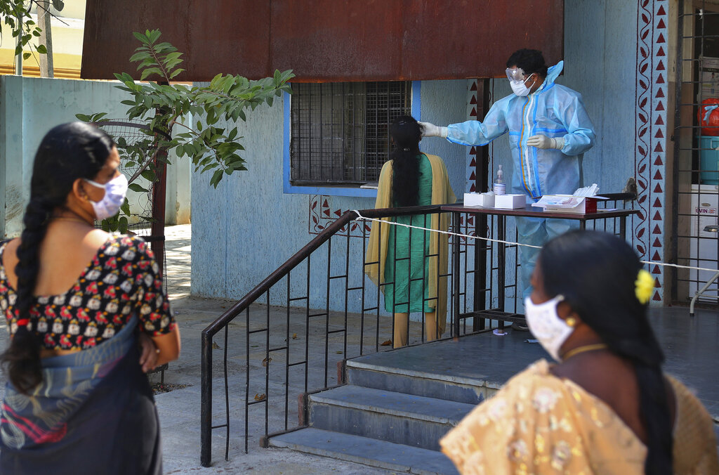 A health worker takes a nasal swab sample of a woman as others wait their turn at a COVID-19 testing center in Hyderabad, India, Monday, Nov. 16, 2020.  A country of nearly 1.4 billion people, India is the world's second most coronavirus affected country after the United States. (AP Photo/Mahesh Kumar A.)