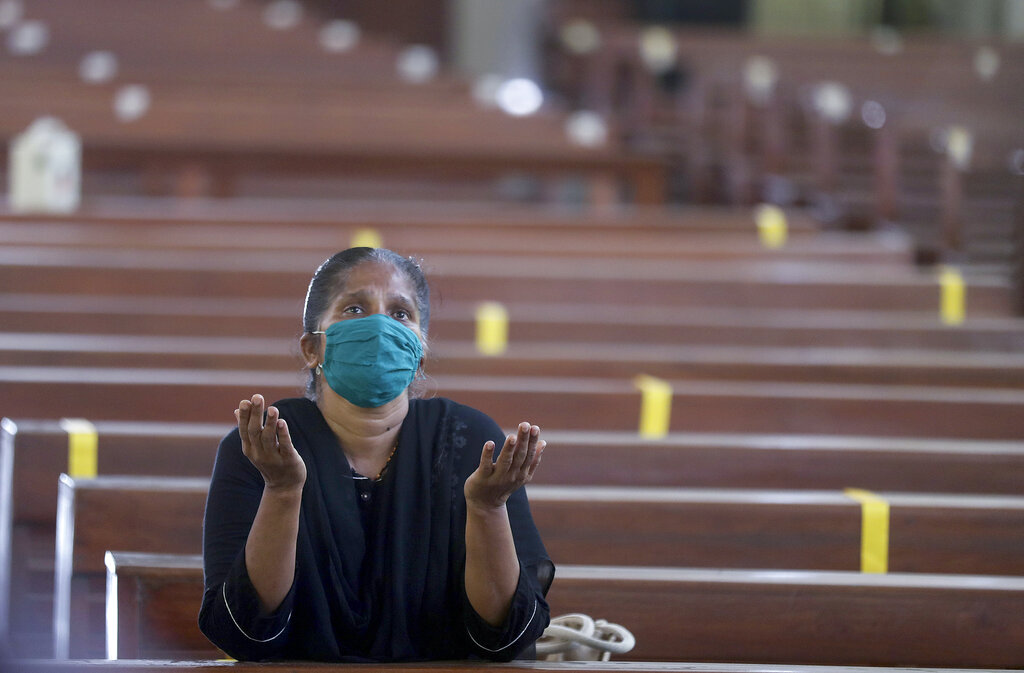 A Christian devotee wearing a mask offers prayers at a Church in Mumbai, India, Monday, Nov. 16, 2020. Religious places across the Maharashtra state reopened for devotees on Monday after remaining closed due to the COVID-19 pandemic. A country of nearly 1.4 billion people, India is the world's second most coronavirus affected country after the United States.(AP Photo/Rafiq Maqbool)
