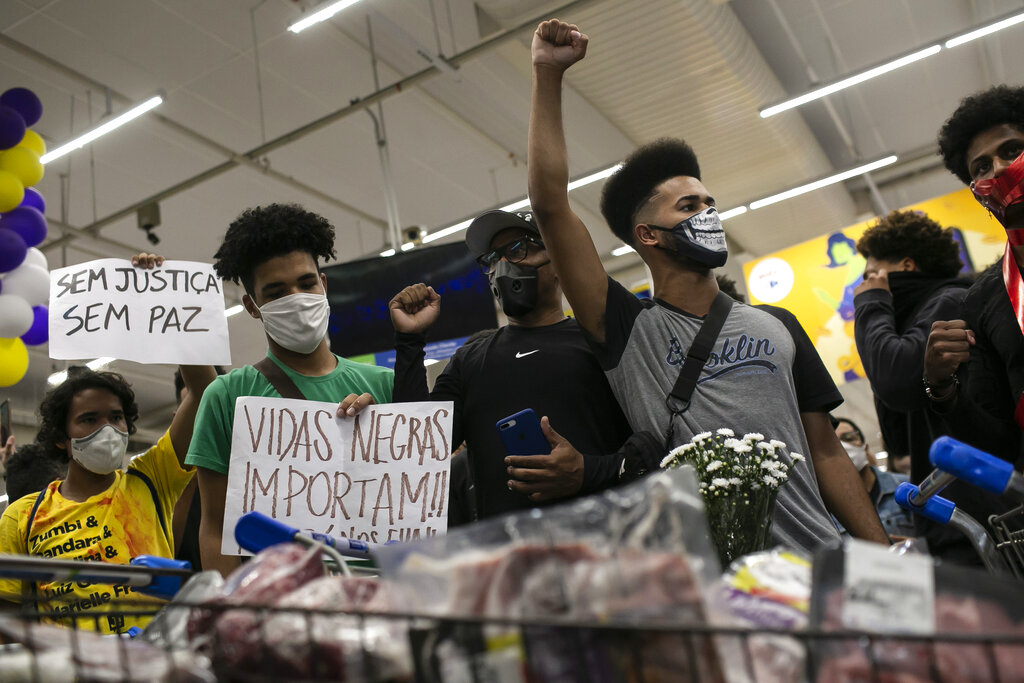 Activists including members of Black Lives Matter demonstrate inside a Carrefour supermarket against the murder of Black man Joao Alberto Silveira Freitas at a different Carrefour the night before, on Brazil's National Black Consciousness Day in Rio de Janeiro, Brazil, Friday, Nov. 20, 2020. Freitas died after being beaten by supermarket security guards in the southern Brazilian city of Porto Alegre, sparking outrage as videos of the incident circulated on social media. (AP Photo/Bruna Prado)