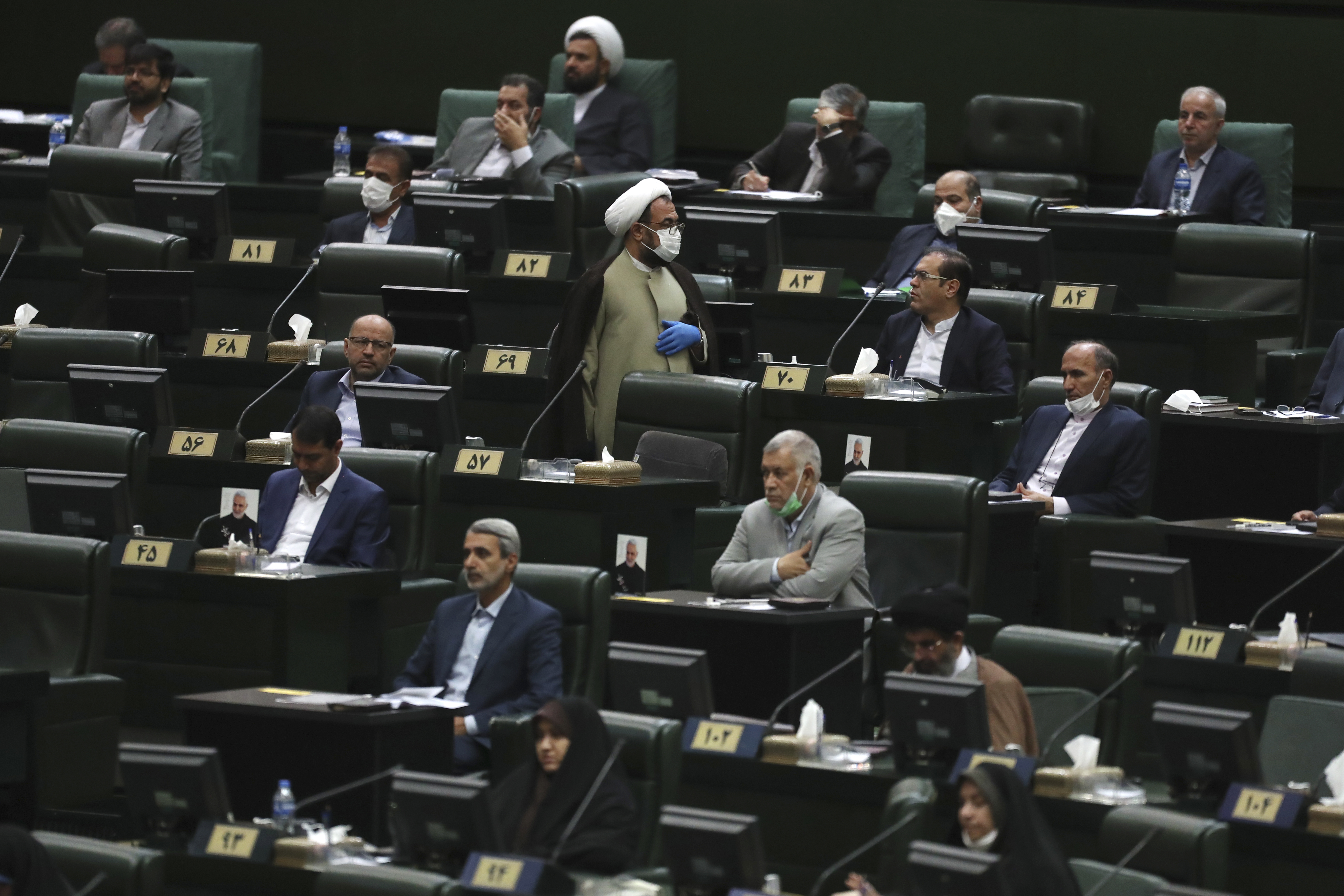 Lawmakers listen to a speech during the inauguration ceremony of Iran's new parliament, in Tehran, Iran, Wednesday, May, 27, 2020. Iran convened its newly elected parliament, dominated by conservative lawmakers and under strict social distancing regulations, as the country struggles to curb the spread of coronavirus that has hit the nation hard. Iran is grappling with one of the deadliest outbreaks in the Middle East. (AP Photo/Vahid Salemi)
