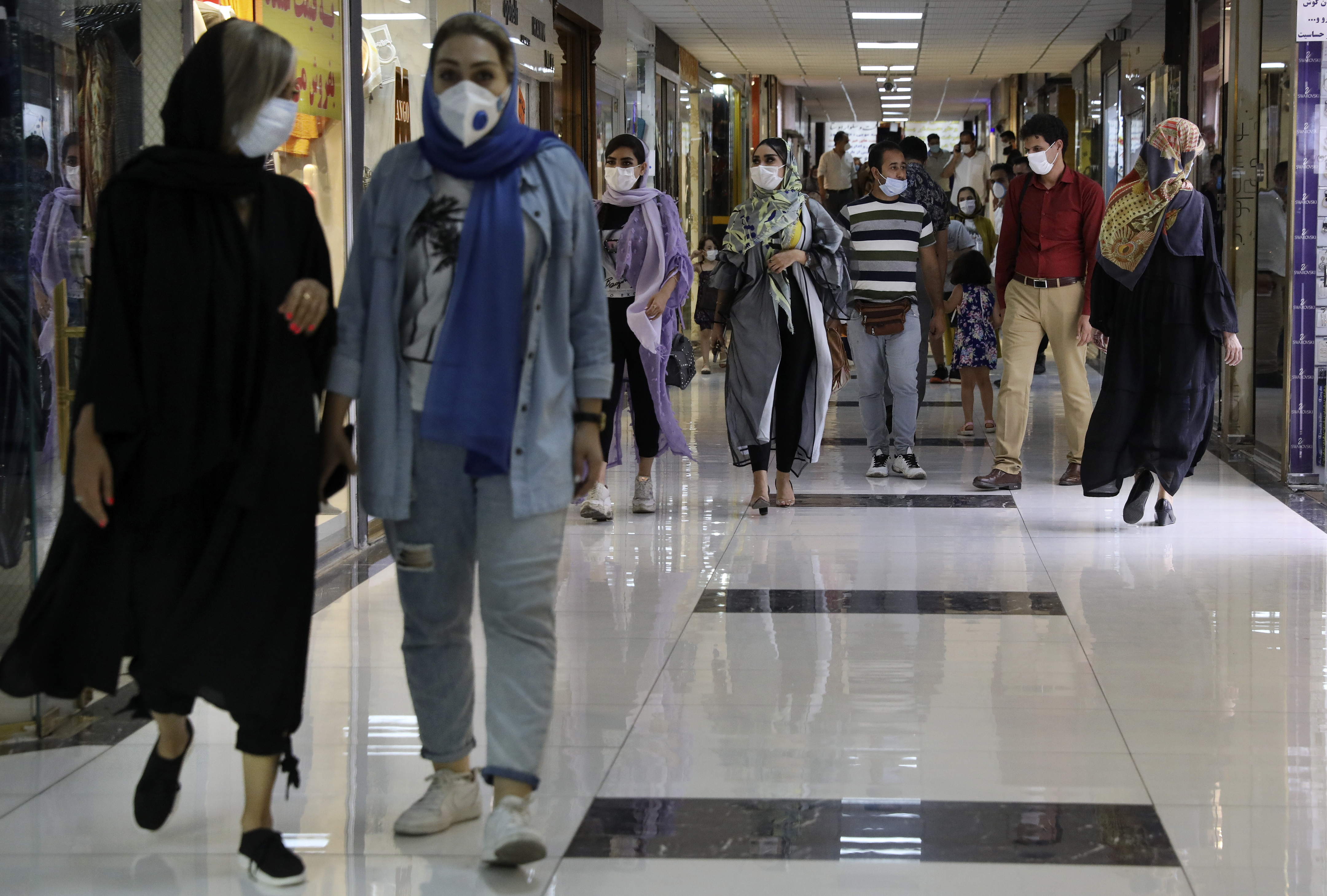 People wearing protective face masks to help prevent the spread of the coronavirus walk through the Nasr Shopping Center in Tehran, Iran, Wednesday, July 15, 2020. Iran's President Hassan Rouhani has said lockdowns over COVID-19 pandemic may lead to street protests over economic problems, though in Tehran, authorities have decided to impose some restrictions again over newly spiking reported deaths from the coronavirus. (AP Photo/Vahid Salemi)