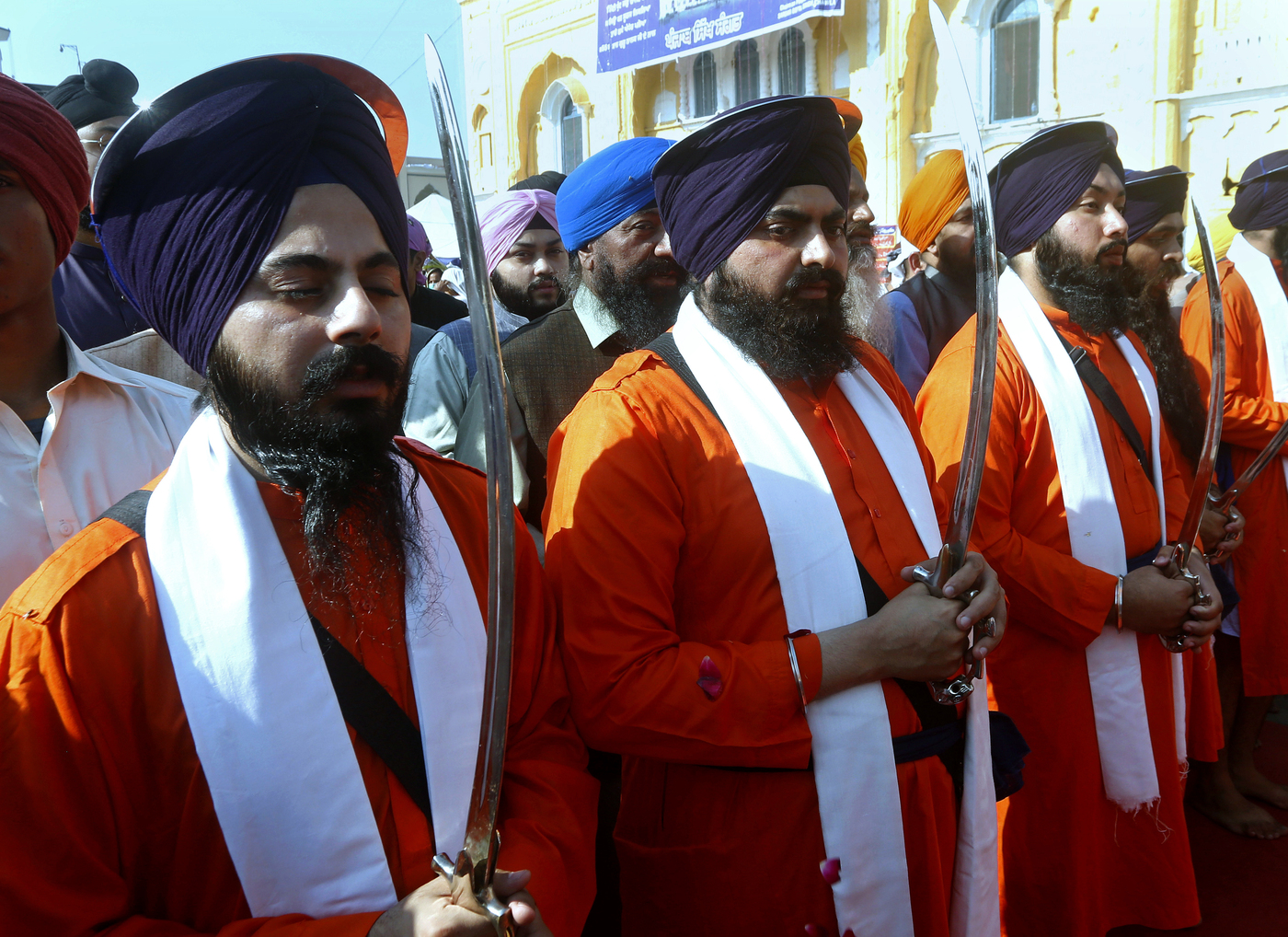 Sikh pilgrims in traditional dress hold ceremonial swords during a religious festival to celebrate the birth anniversary of their spiritual leader Baba Guru Nanak Dev, at Nankana Sahib, near Lahore, Pakistan, Monday, Nov. 30, 2020. Thousands of pilgrims from various countries arrived in Pakistan to participate in three-day festival to celebrate the 551st birth anniversary of the founder of the Sikh religion. (AP Photo/K.M. Chaudary)