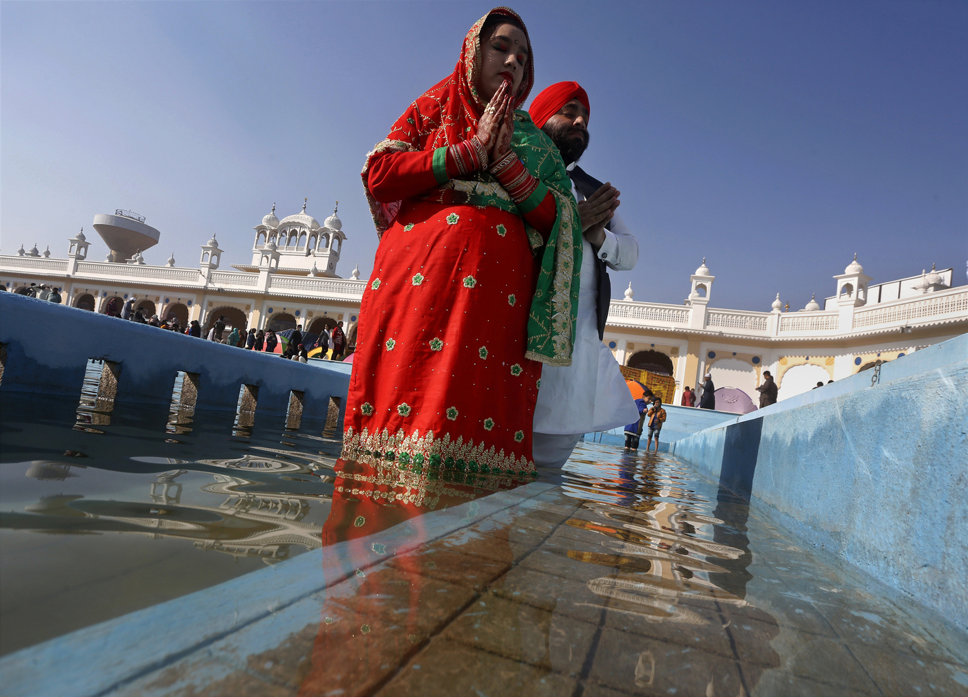A Sikh couple perform rituals during a religious festival to celebrate the birth anniversary of their spiritual leader Baba Guru Nanak Dev, at Nankana Sahib, near Lahore, Pakistan, Monday, Nov. 30, 2020. Thousands of pilgrims from various countries arrived in Pakistan to participate in three-day festival to celebrate the 551st birth anniversary of the founder of the Sikh religion. (AP Photo/K.M. Chaudary)