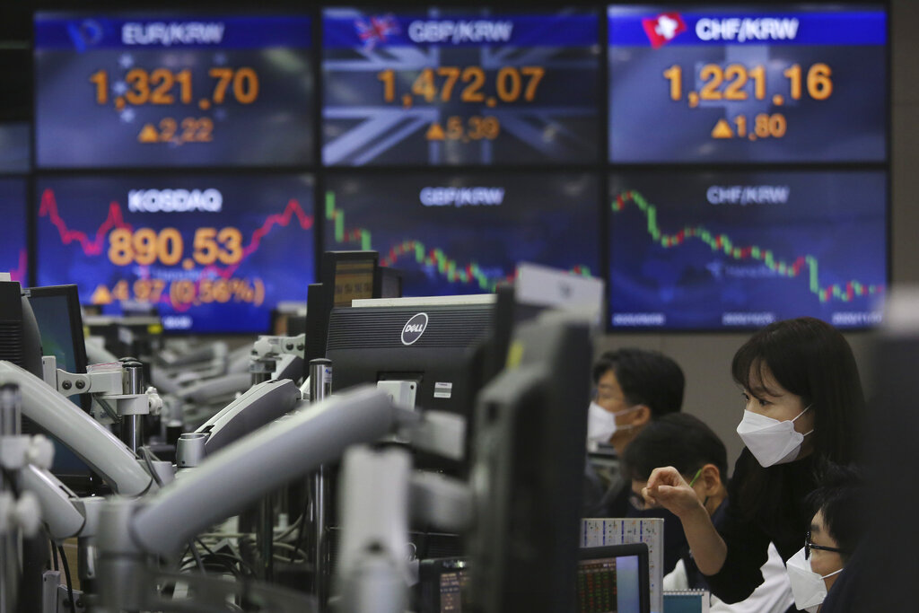 Currency traders watch monitors at the foreign exchange dealing room of the KEB Hana Bank headquarters in Seoul, South Korea, Monday, Nov. 30, 2020. Asian shares were mixed on Monday on renewed caution despite a record high finish on Wall Street last week driven by hopes for a COVID-19 vaccine and relief for the global economy. (AP Photo/Ahn Young-joon)