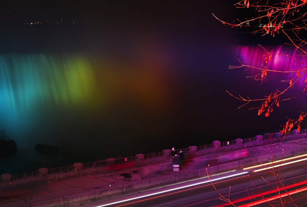 Cars drive past the glowing waterfall during the annual Winter Festival of Lights in Niagara Falls, Ontario, Sunday, Dec. 6, 2020. (Nathan Denette/The Canadian Press via AP)