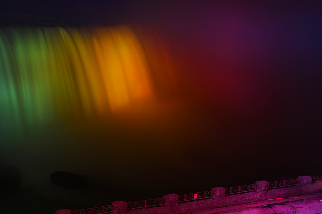 A glowing waterfall is shown during the annual Winter Festival of Lights in Niagara Falls, Ontario, Sunday, Dec. 6, 2020. (Nathan Denette/The Canadian Press via AP)