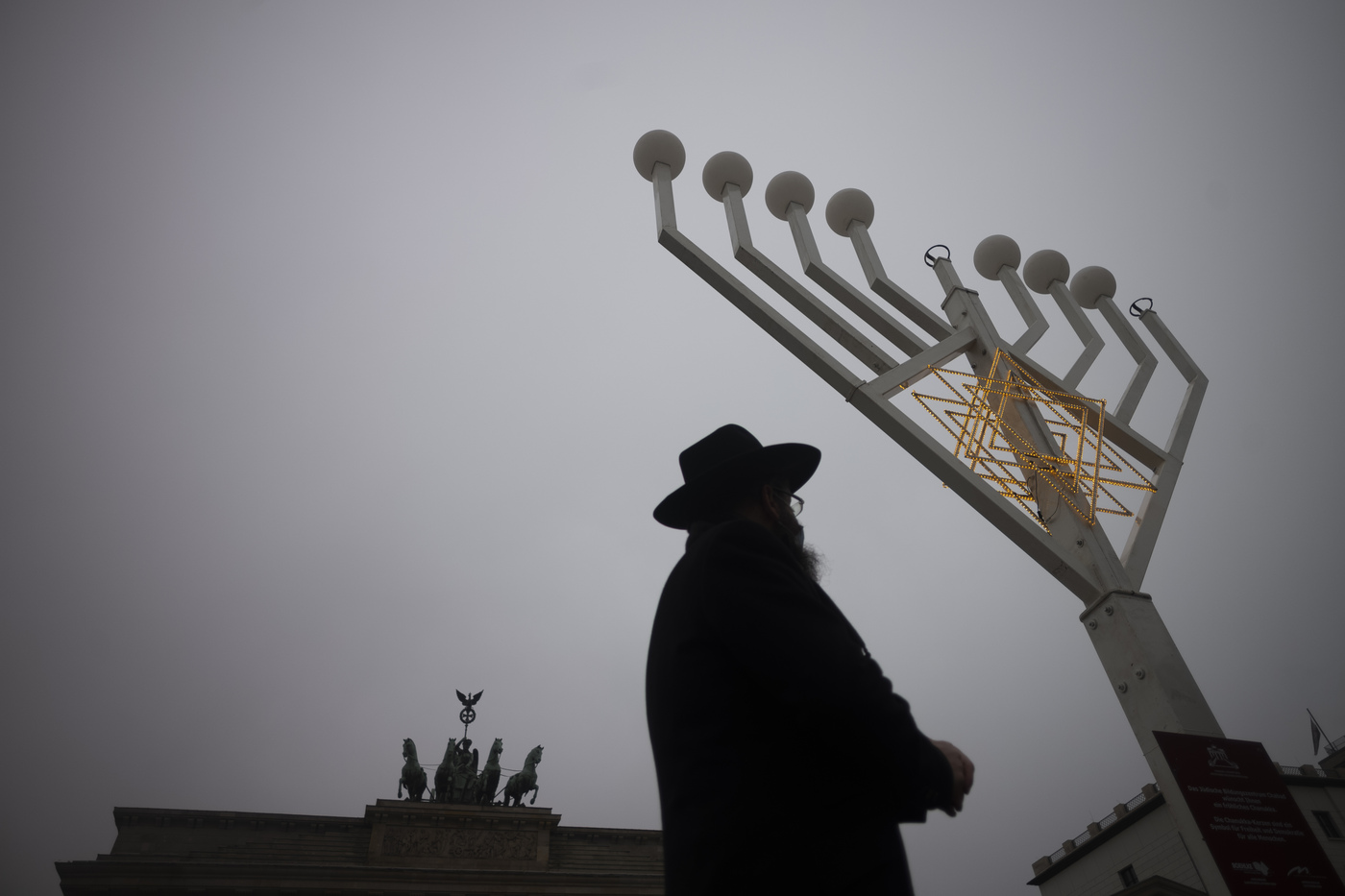 Rabbi Yehuda Teichtal inspects a giant Hanukkah Menorah, set up by the Jewish Chabad Educational Center ahead of the Jewish Hanukkah holiday, at the Pariser Platz in Berlin, Germany, Thursday, Dec. 10, 2020. (AP Photo/Markus Schreiber)